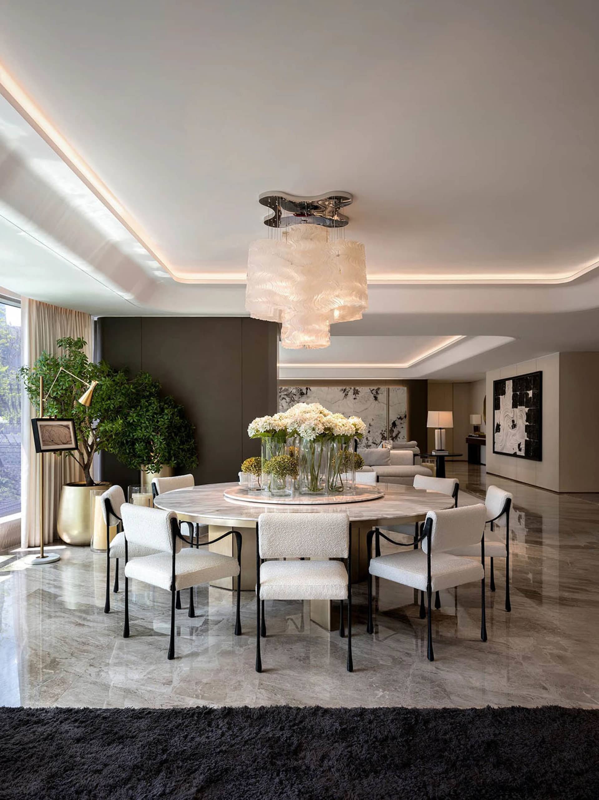 Modern dining room with marble flooring, round table, and white chairs.