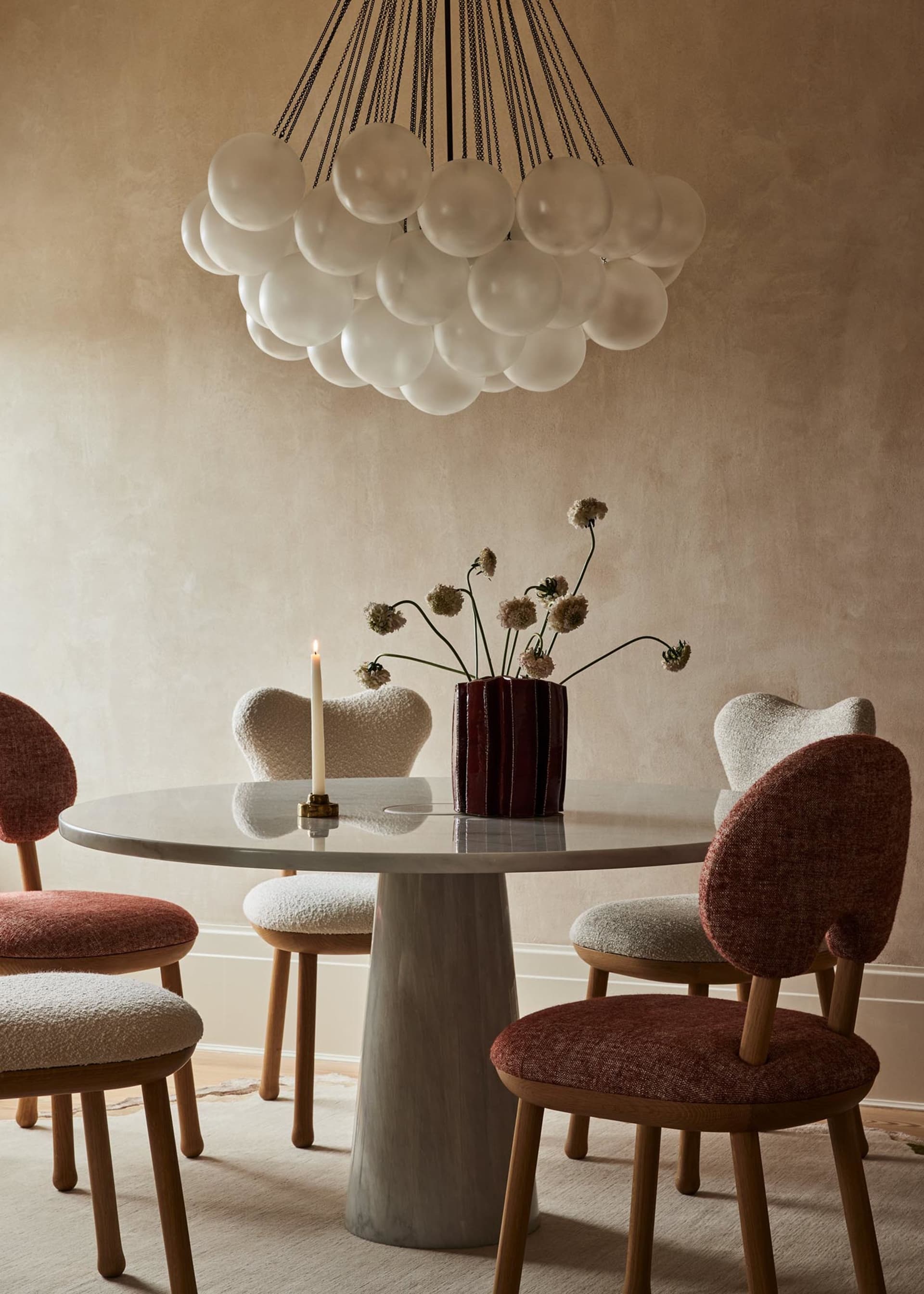 Modern dining room with marble table, wooden chairs, and fabric upholstery
