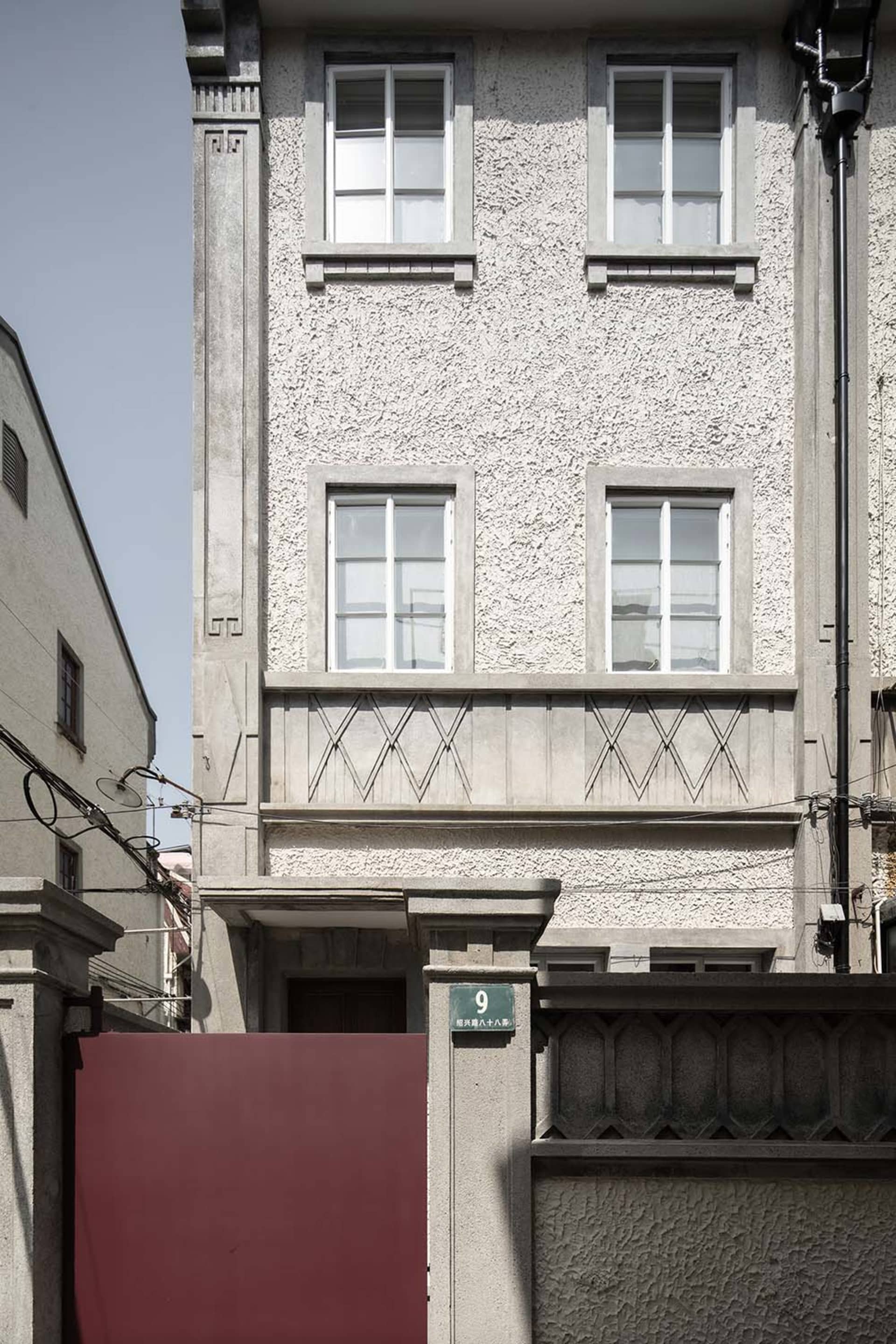 Concrete facade with large windows and decorative balconies.