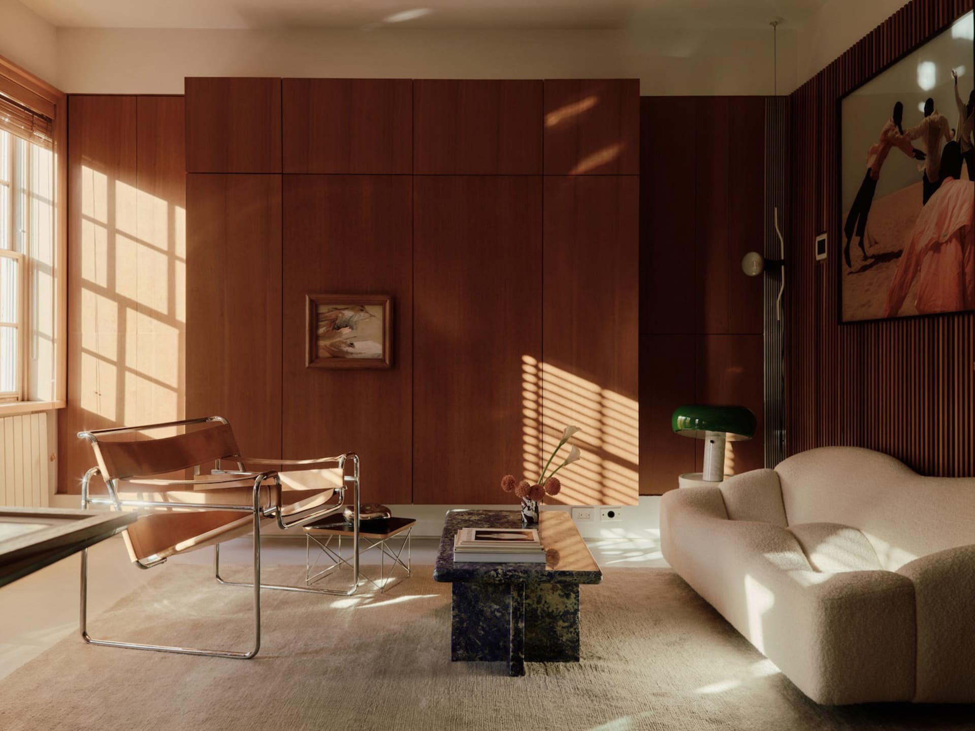 A modern living room featuring wooden walls, a white sofa, and minimalist furniture.