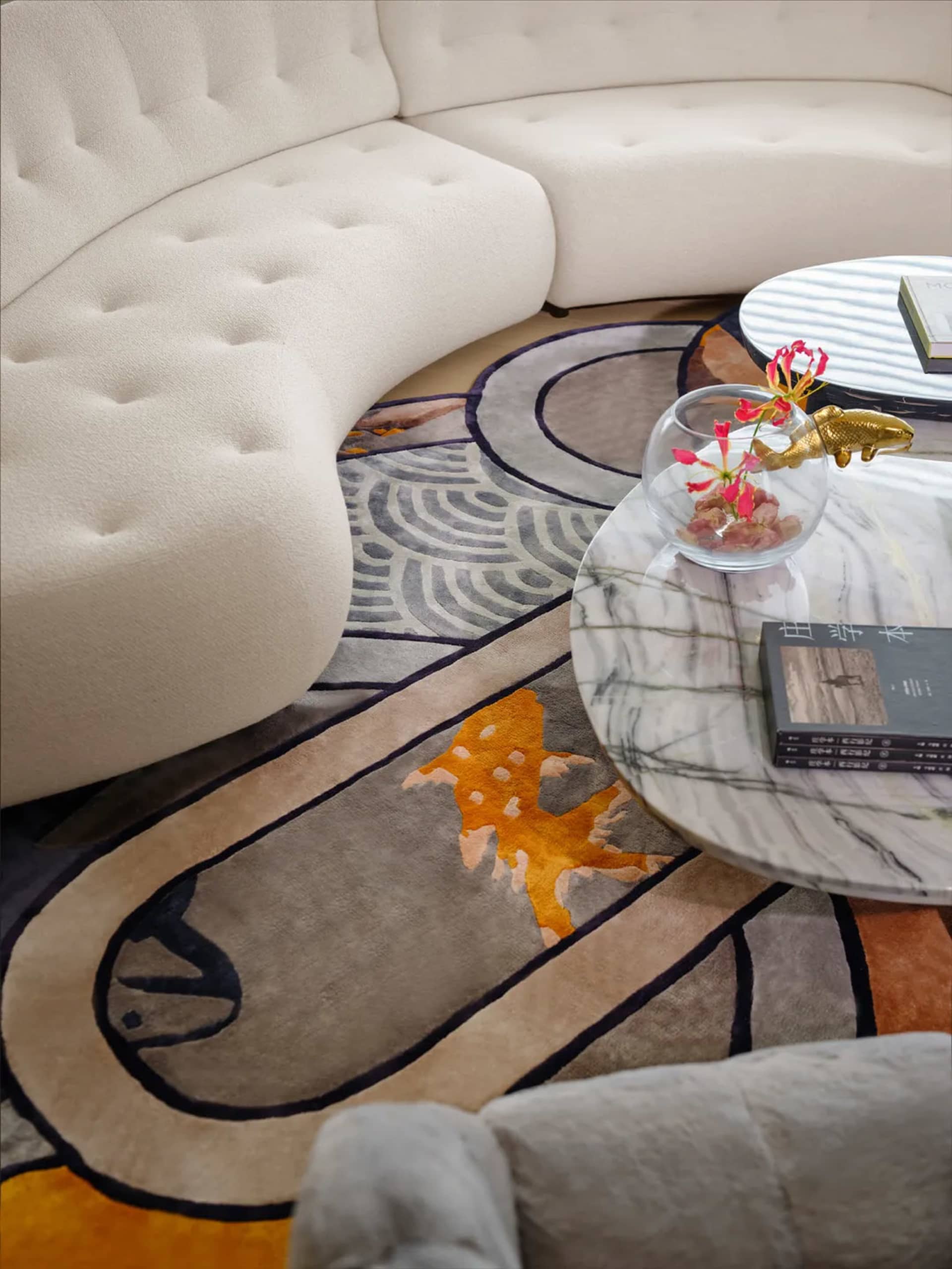 A modern minimalist living room with a white curved sofa and a colorful abstract carpet