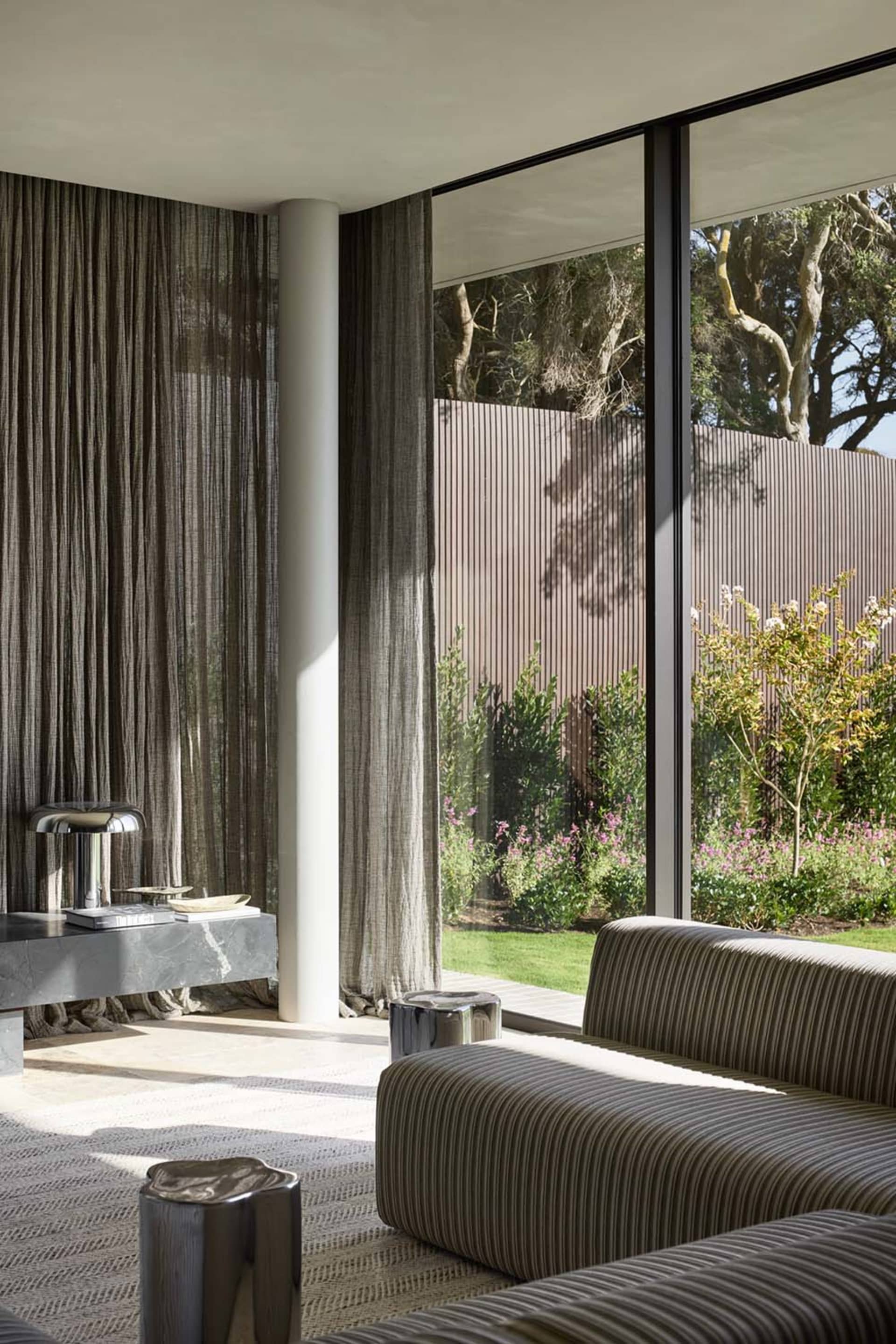 Modern living room featuring textured glass, metal accents, and fabric seating.