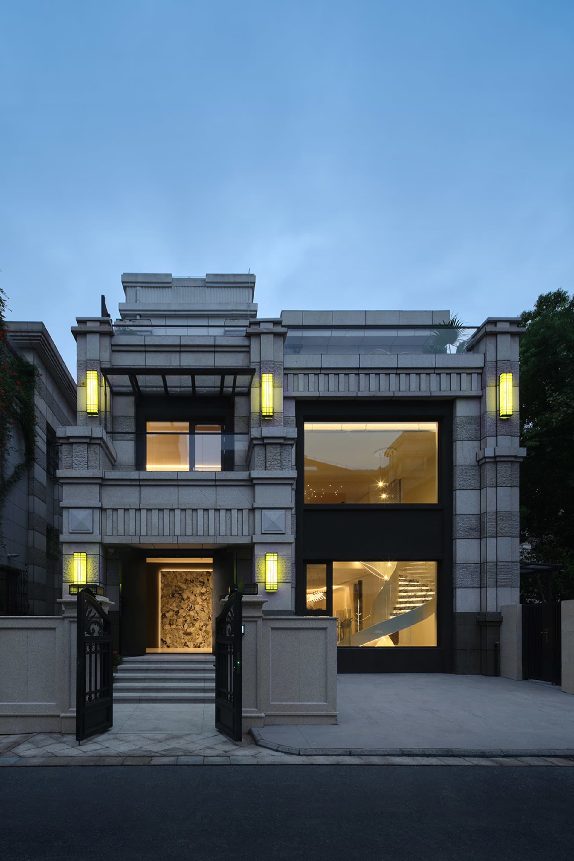 A modern residential home featuring concrete, glass, and stone materials.