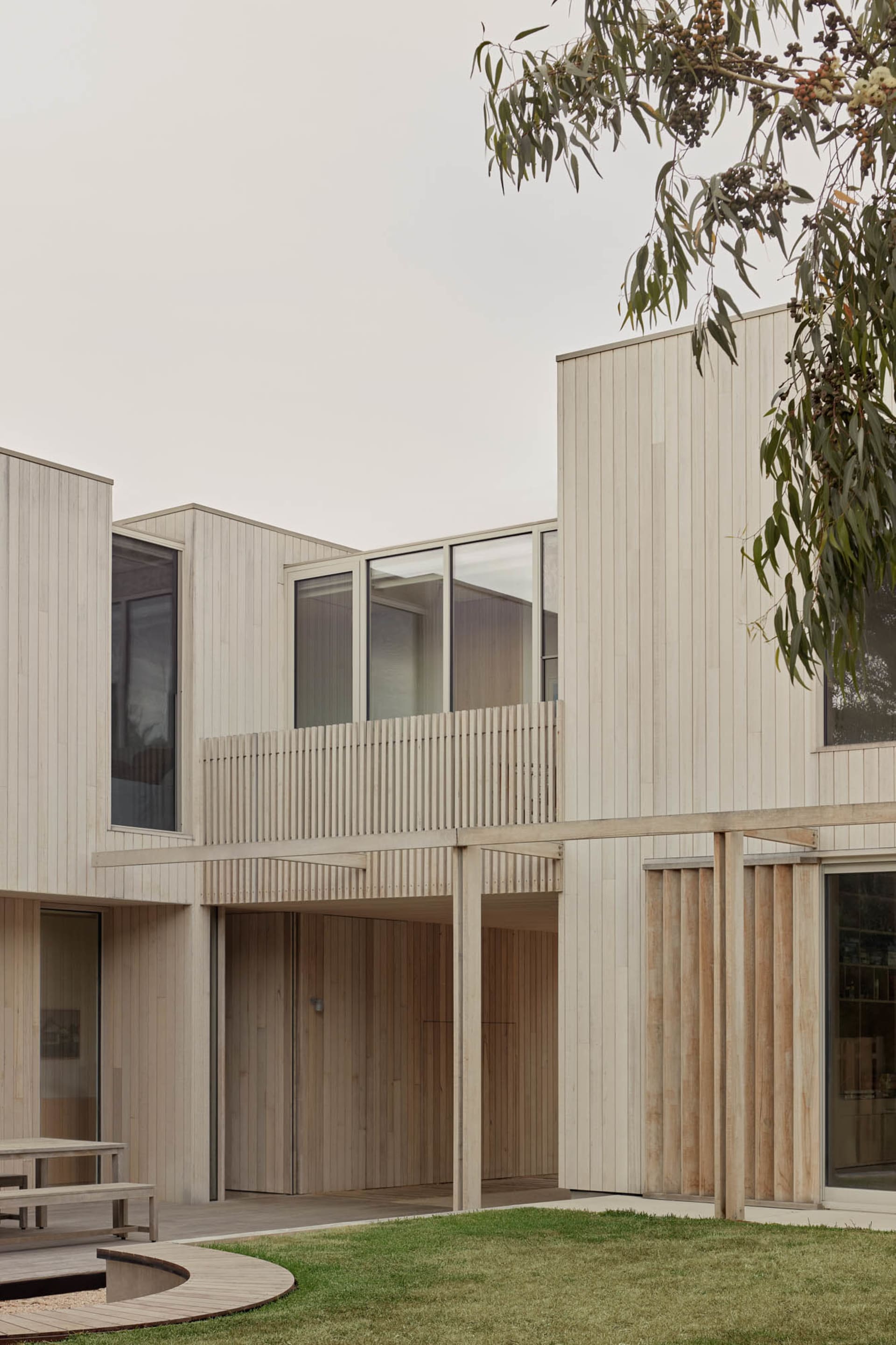 Modern residential building with wooden exterior and large windows.