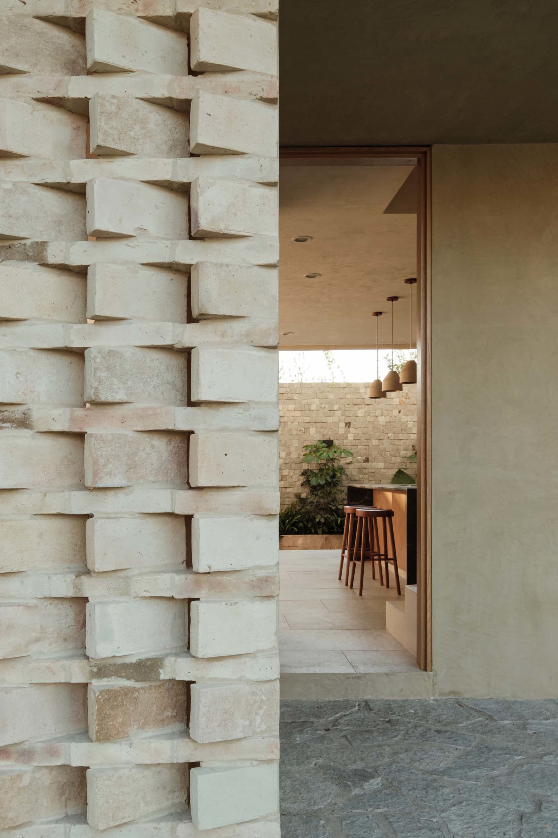 An interior space with modern design elements, featuring a mix of concrete and brick textures and natural stone.