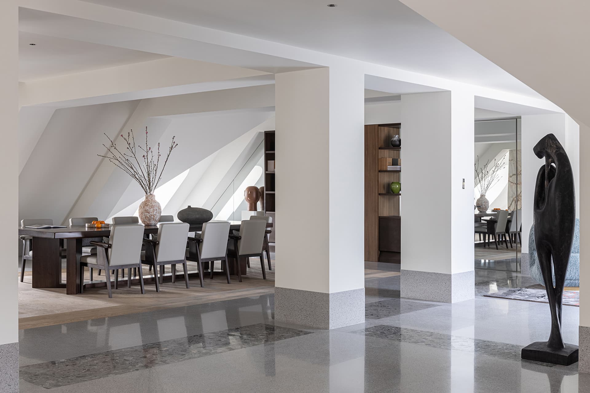 A modern residential interior featuring concrete, wood, and marble finishes.