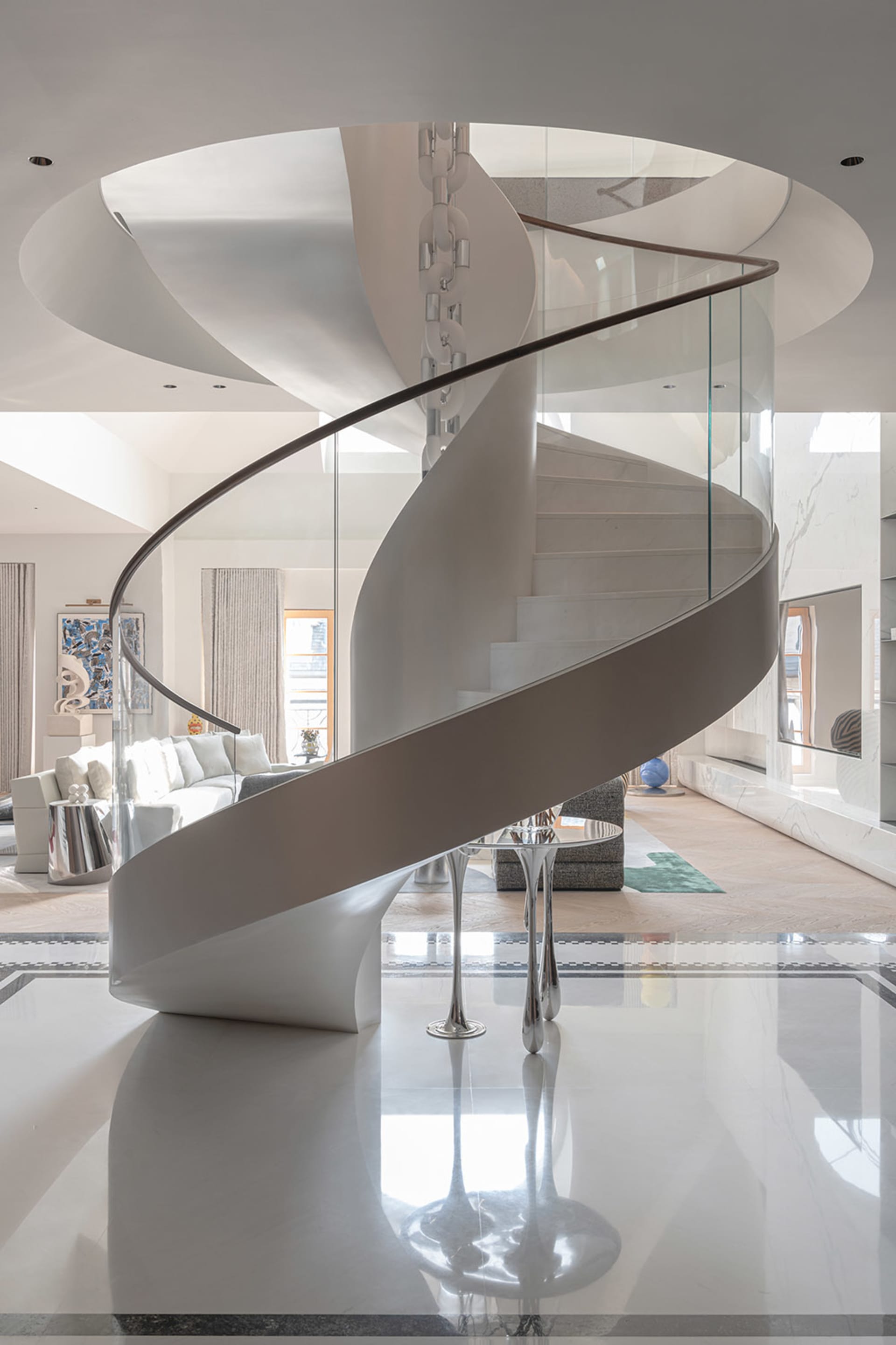 Modern, stylish, and elegant white spiral staircase with glass railings and a circular ceiling design in a contemporary inter