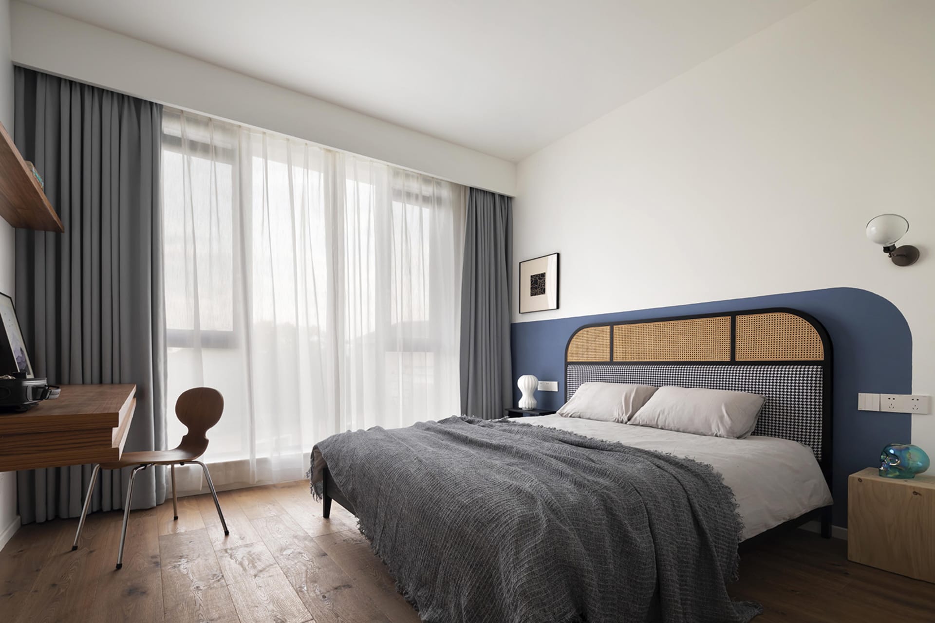 A modern bedroom featuring wooden furniture and fabric bedding.