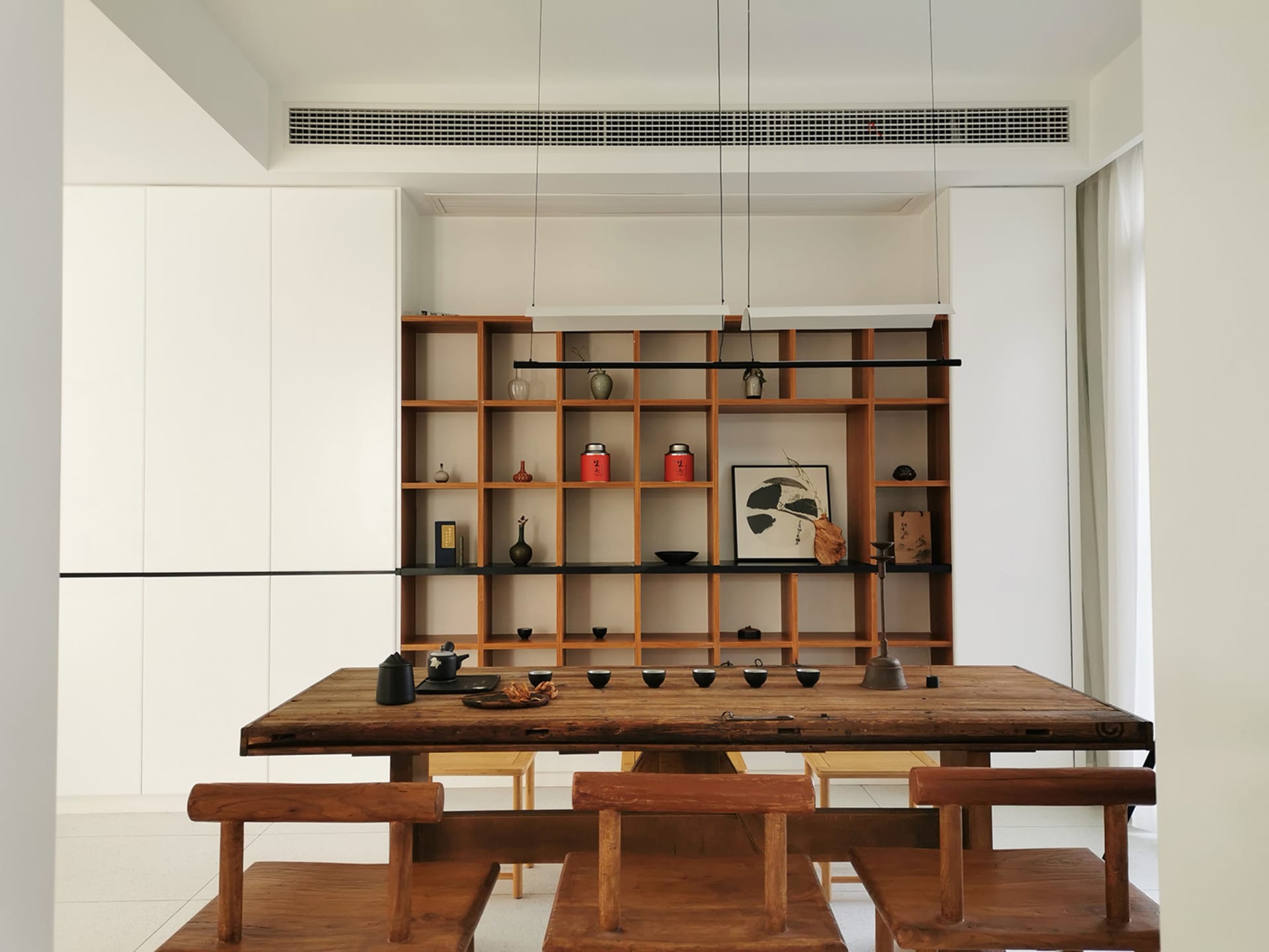 Modern living room featuring wooden furniture, glass surfaces, and metal accents.