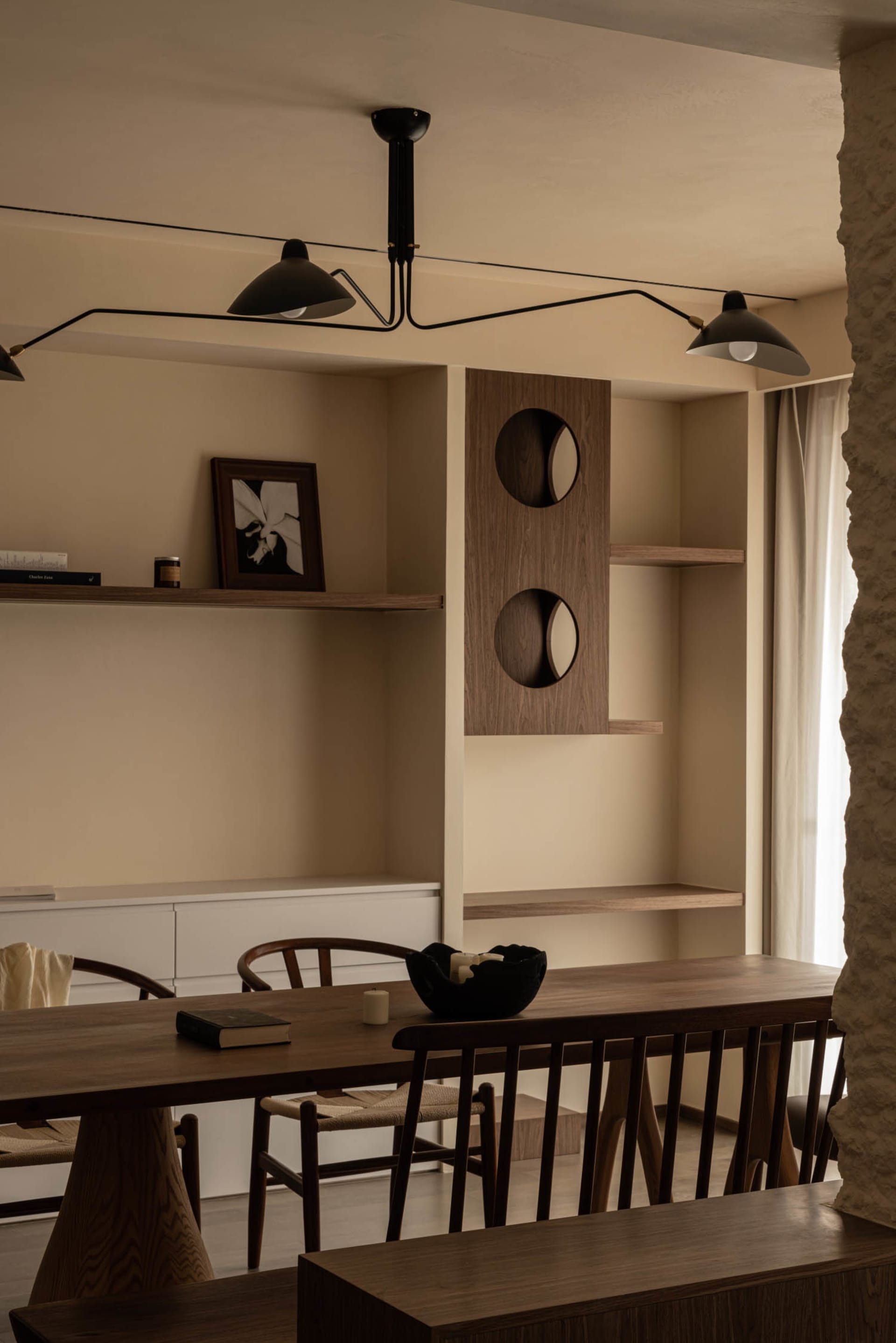 A modern minimalist dining room with wooden furniture and minimalist decor, featuring a long wooden table, chairs, and decora