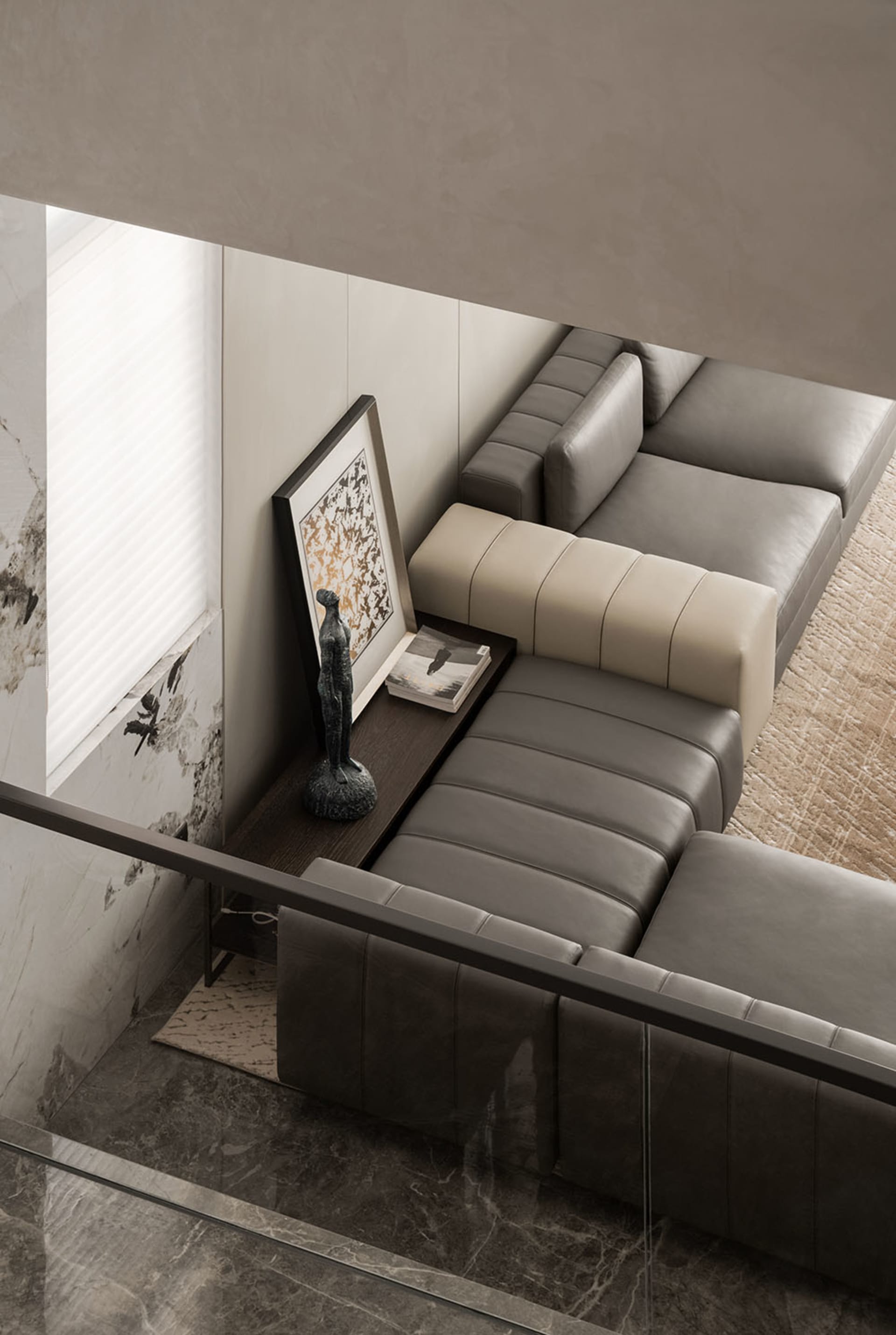 A modern living room featuring a couch upholstered in leather and positioned on a marble floor.