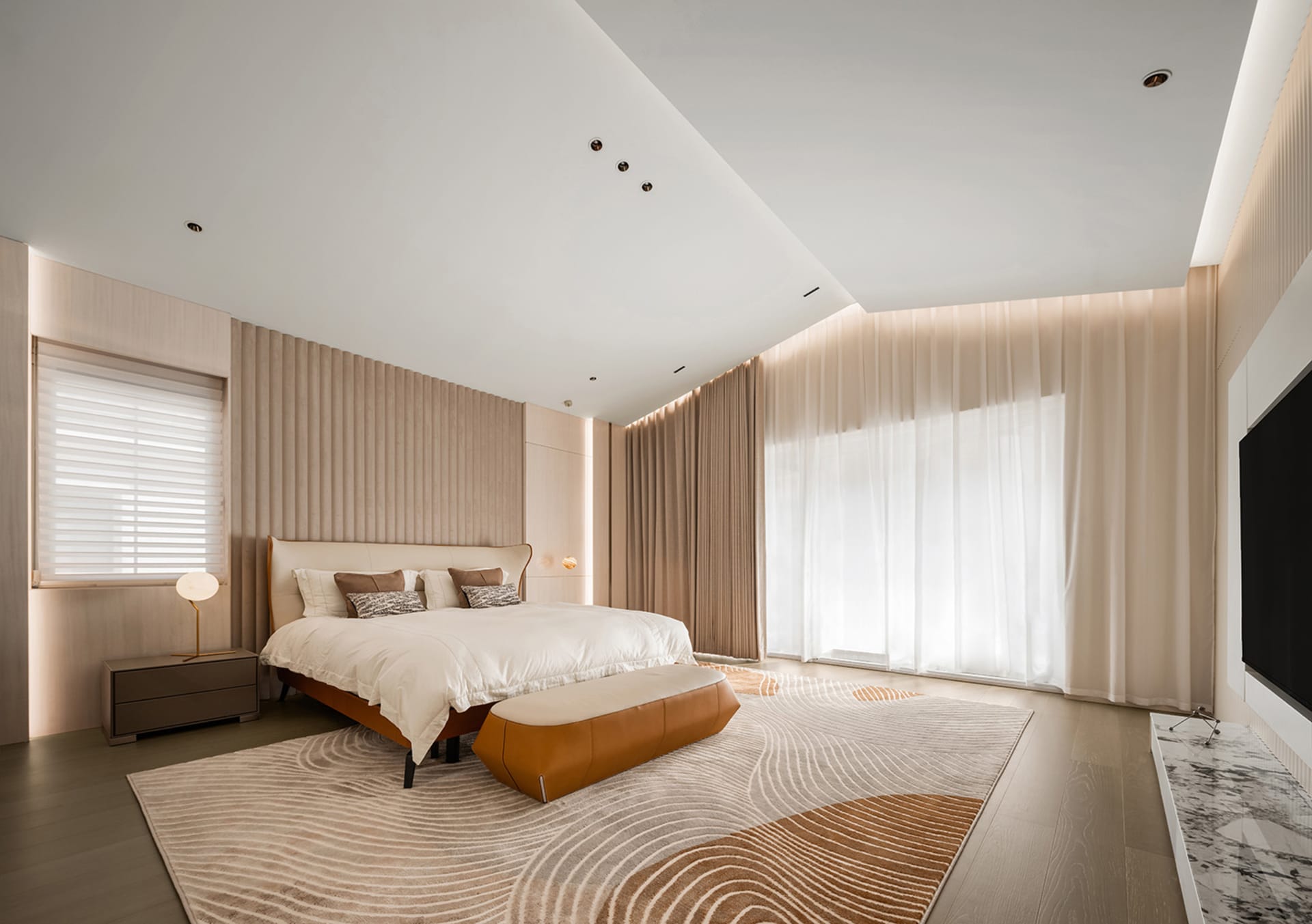 A modern bedroom features a brown leather bed, white curtains, and a patterned rug.