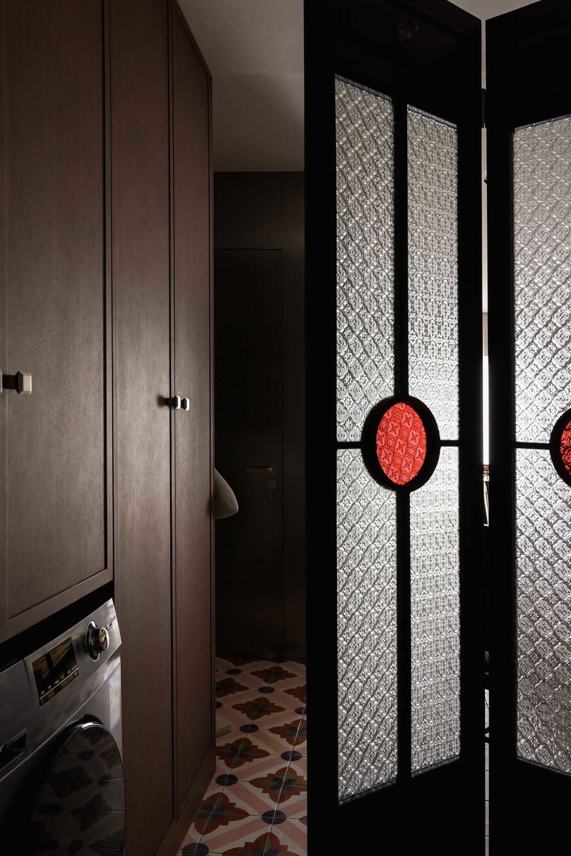 Modern interior with glass split door and patterned tiled floor.