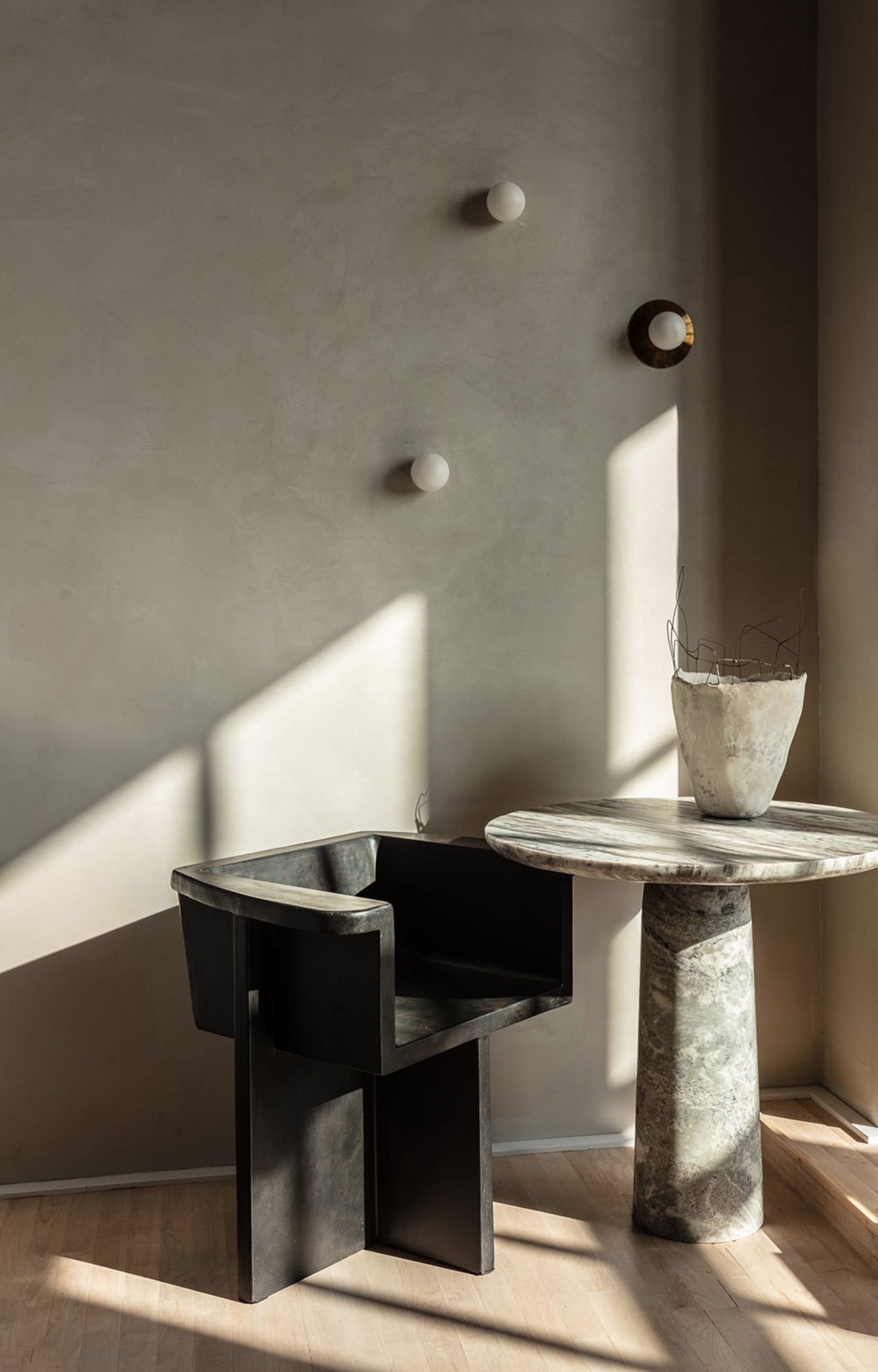 A sleek, modern metal stool in a contemporary living room setting.