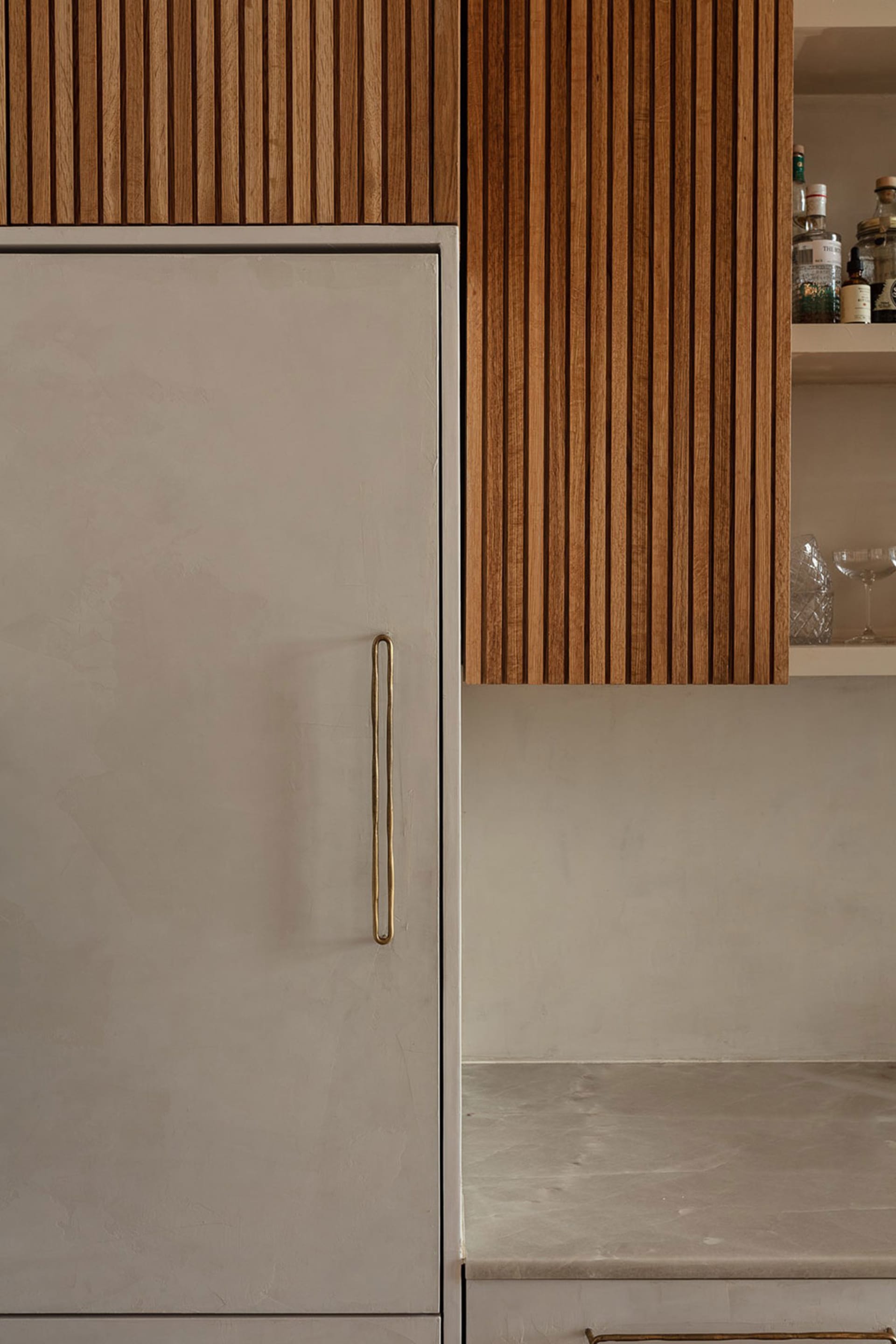 Modern minimalist kitchen featuring wooden cabinets and concrete countertops.