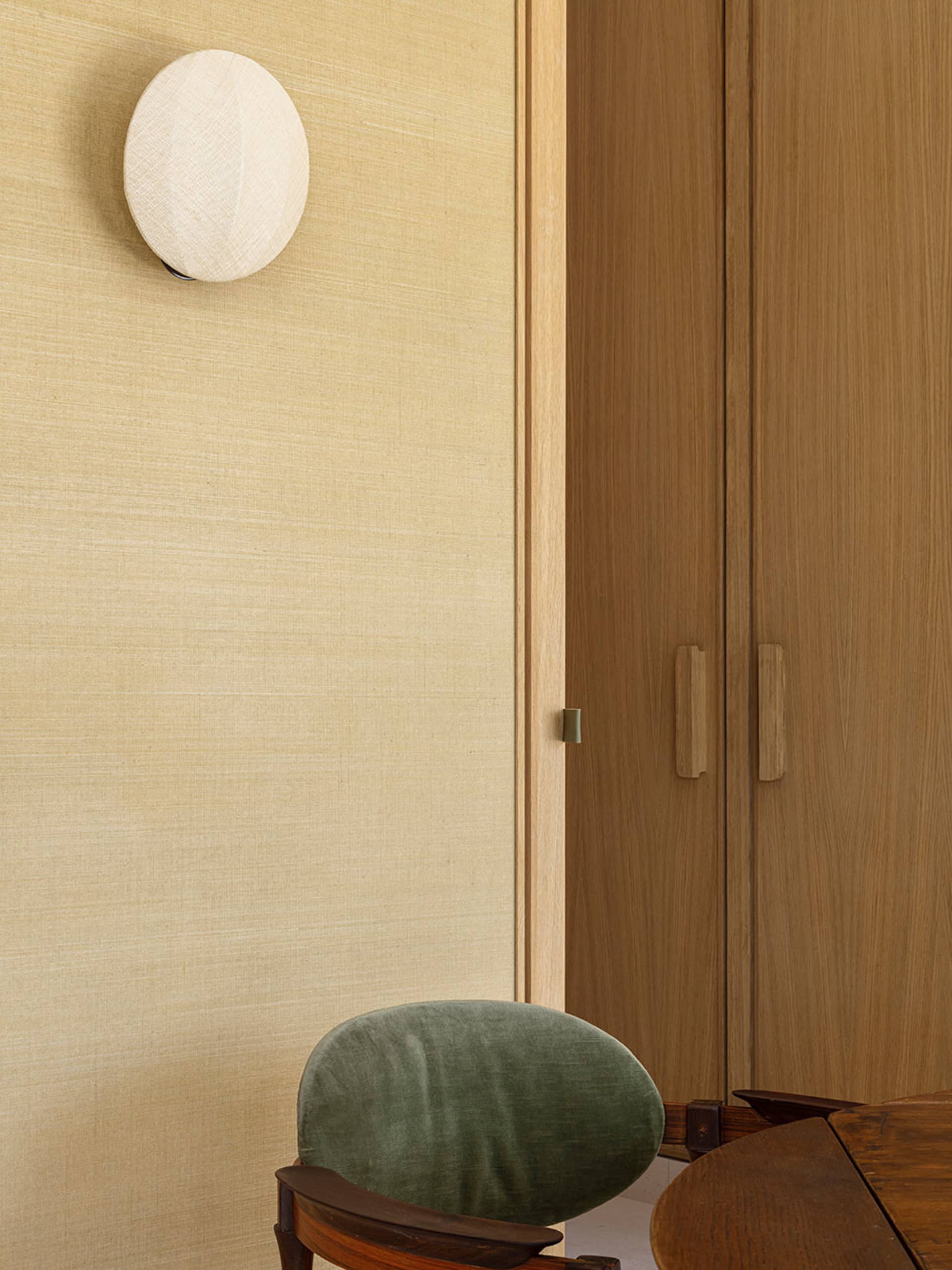 A minimalist office space featuring wooden furniture with a textured fabric chair.