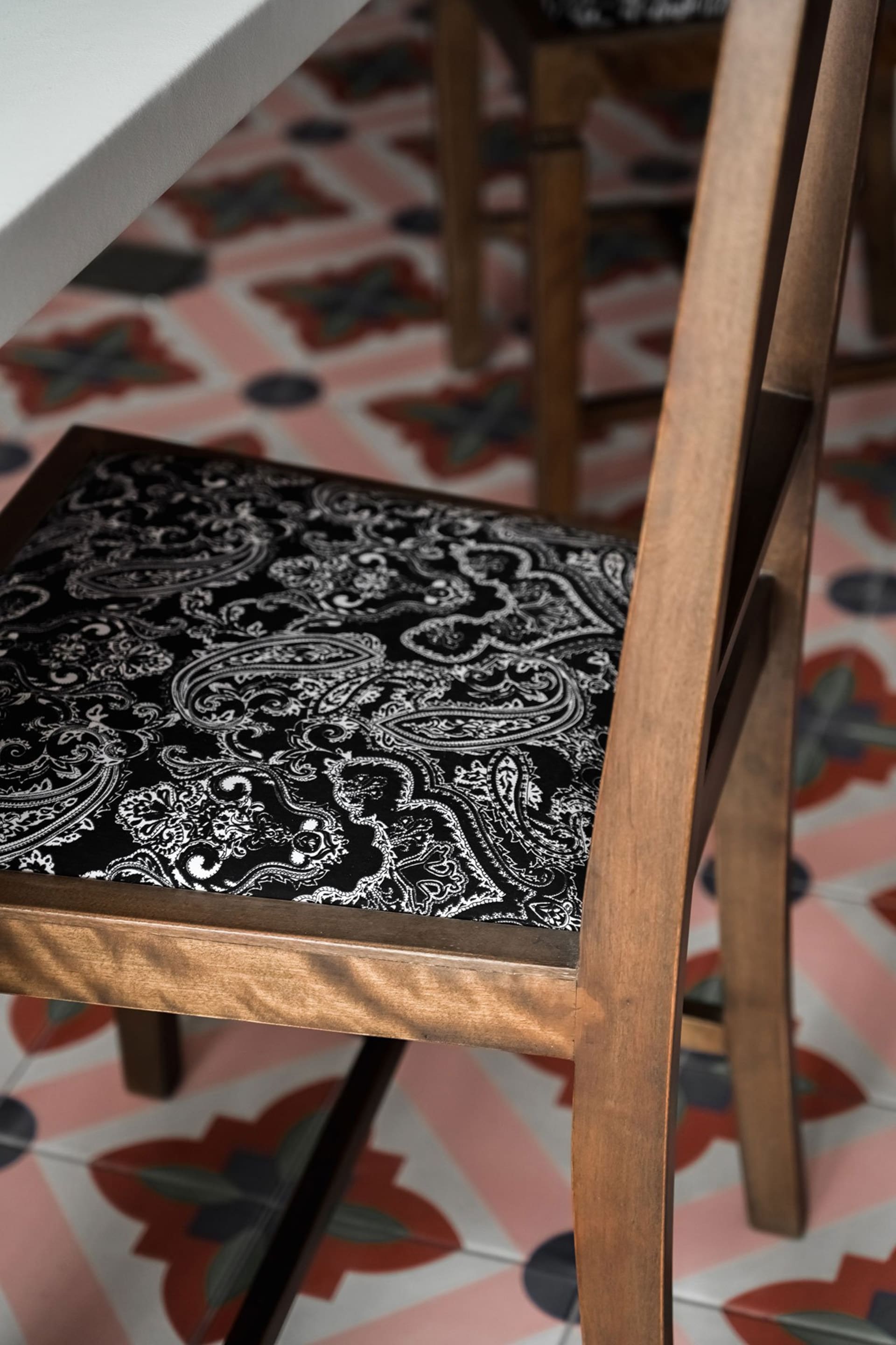 Wooden chair with a black and white paisley pattern cushion