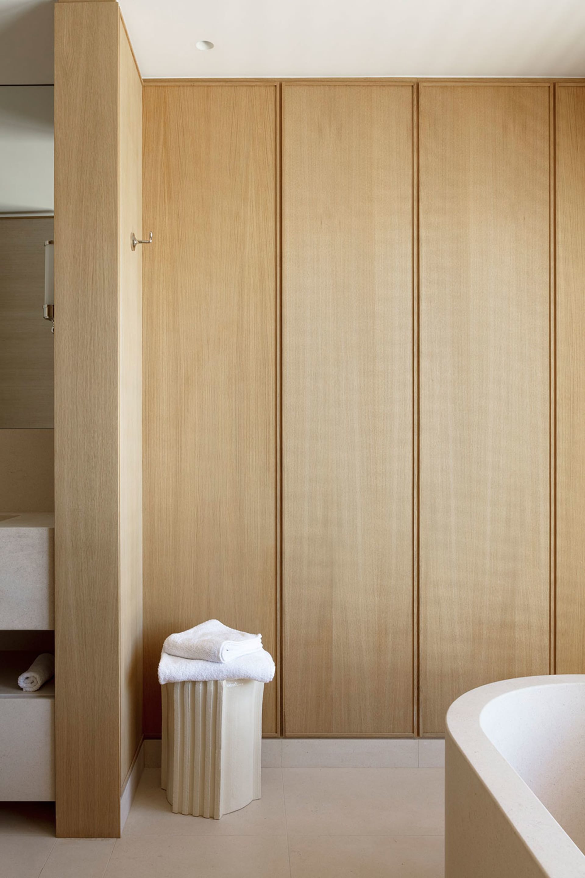 A minimalist bathroom with wooden paneling and a terrazzo floor.