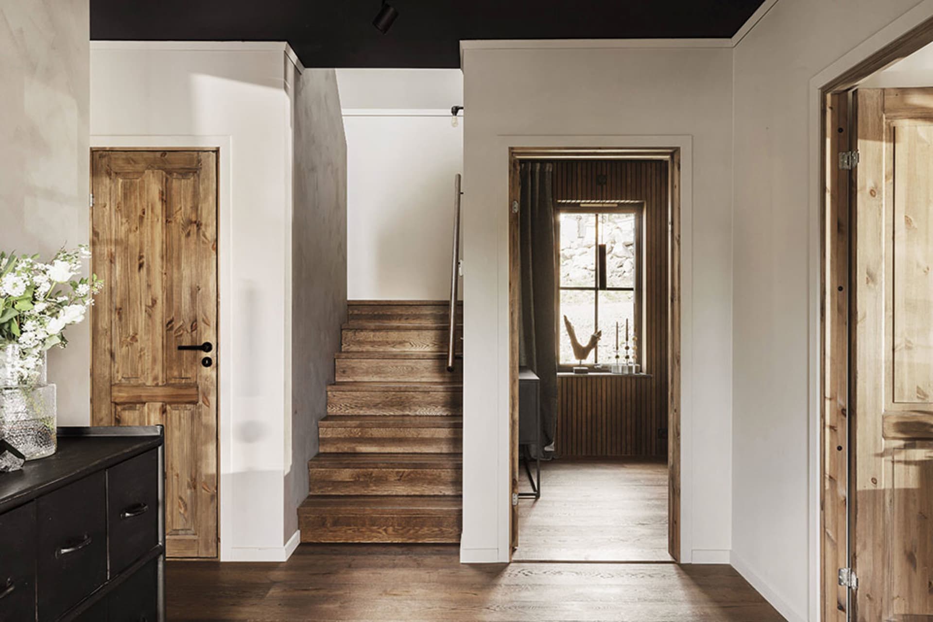 A modern interior design featuring wooden stairs leading to a different level within a residential or commercial building.