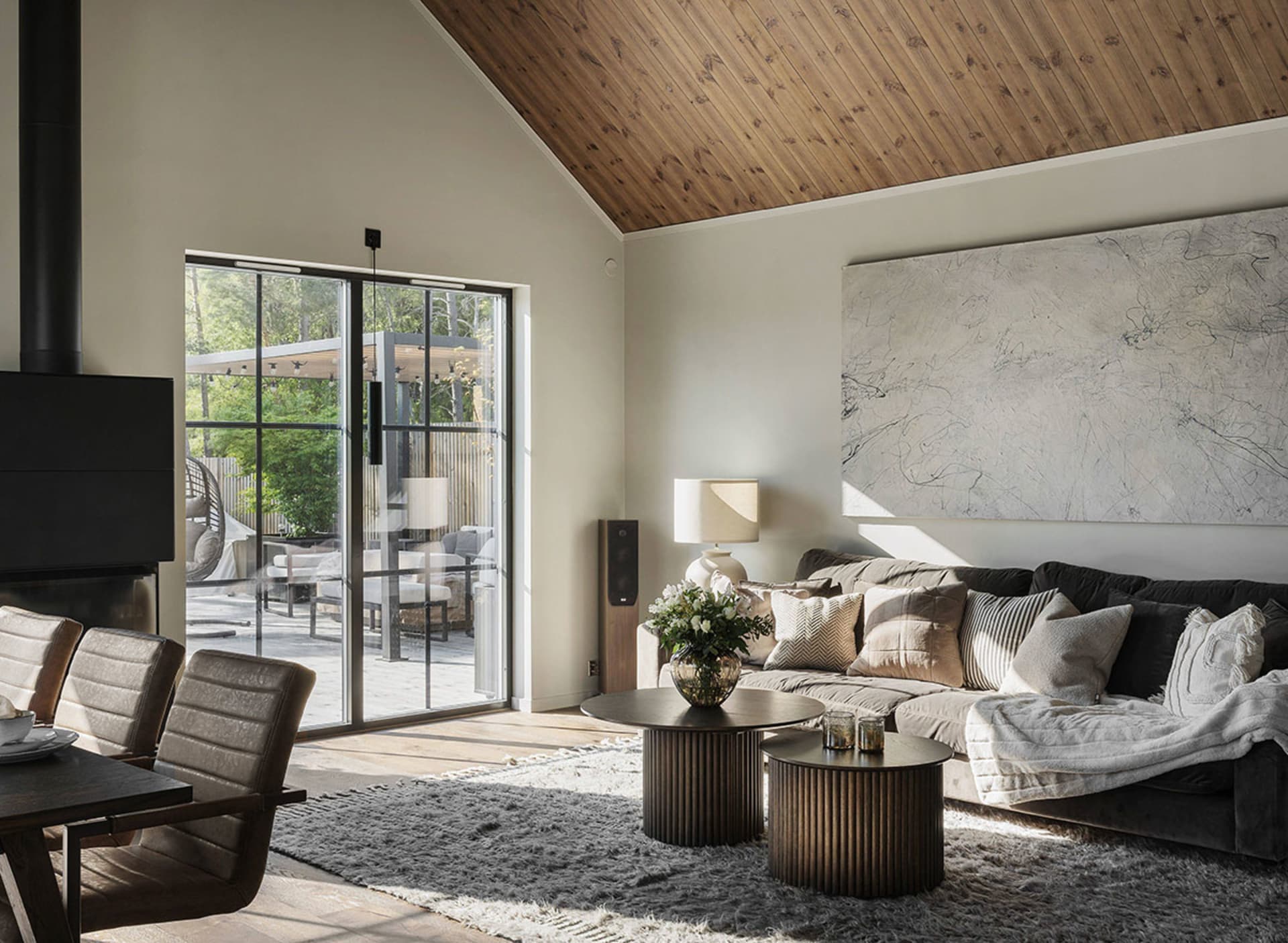 A modern living room with steel finishes, wooden beams, and upholstered furniture.