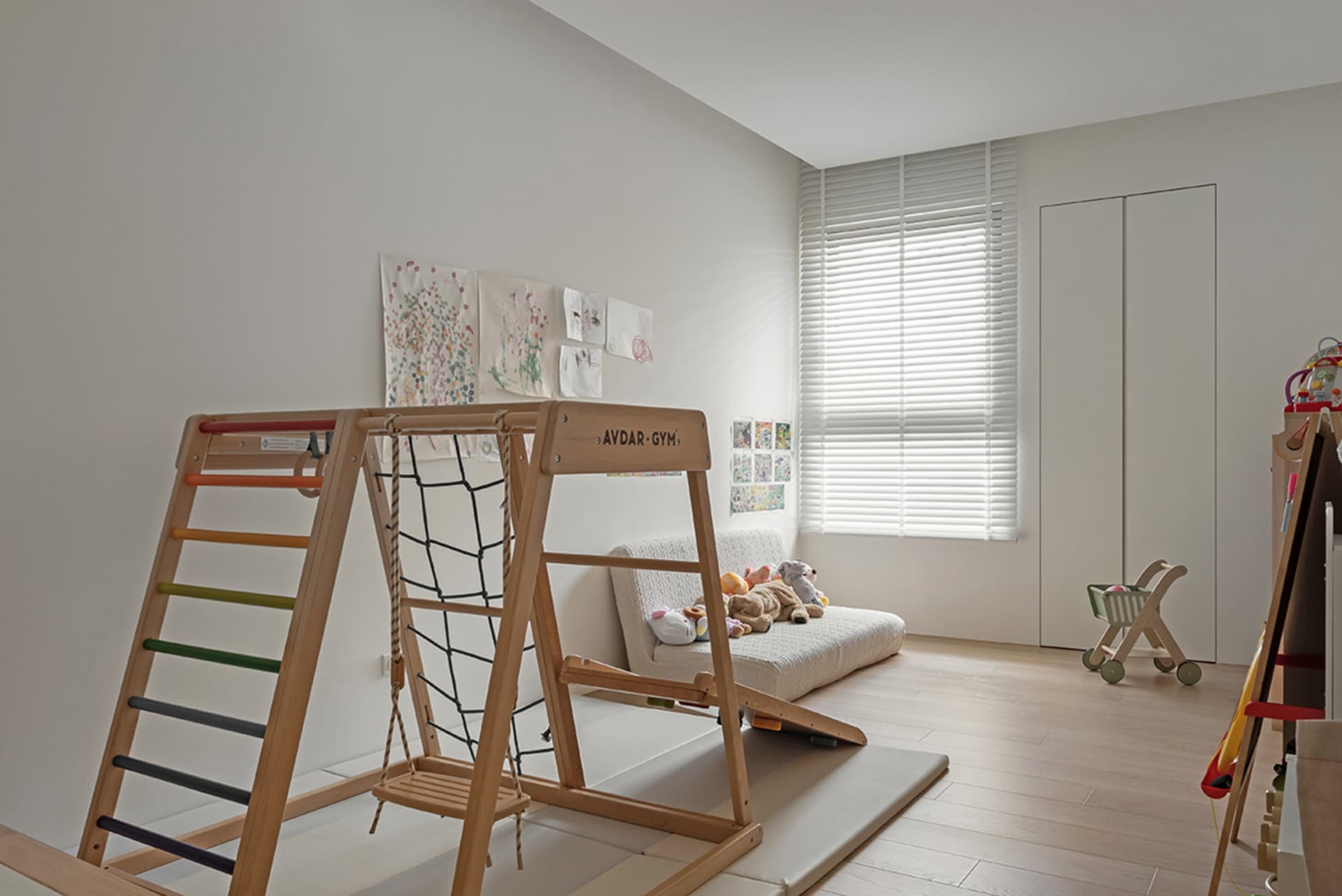 Modern children's room featuring a play space with wooden equipment and a couch.