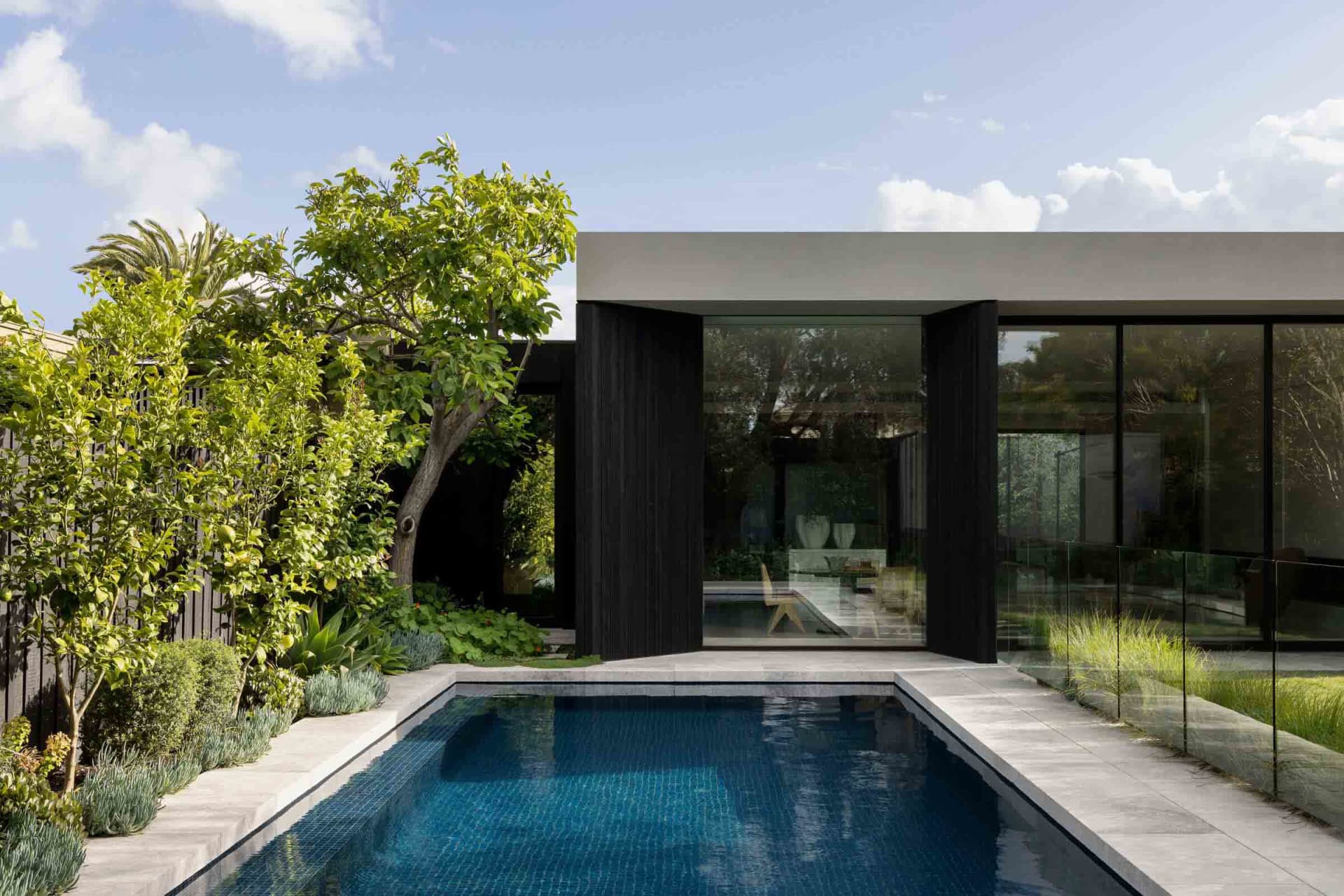 A modern residential building featuring glass and concrete materials.