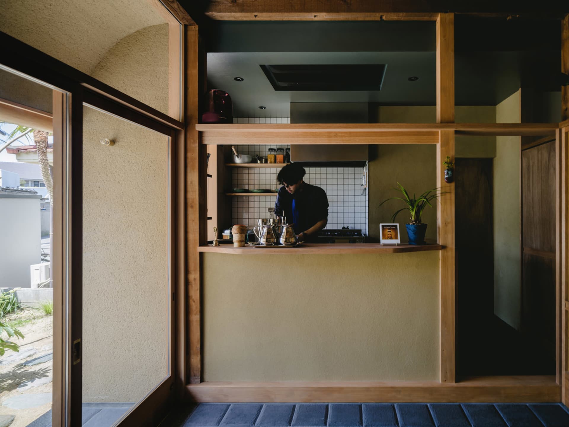 A modern coffee shop counter with wood elements and a person preparing coffee.