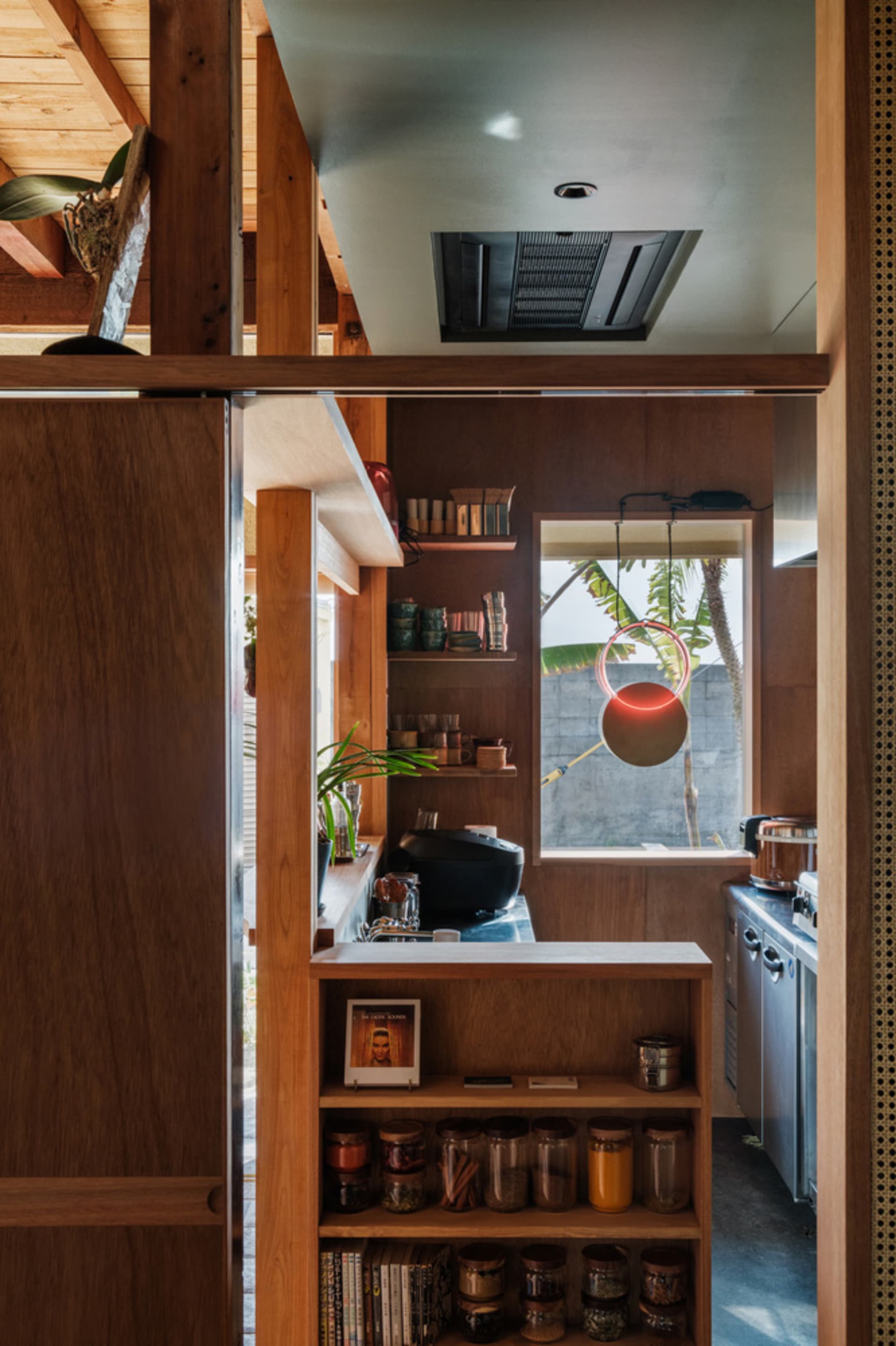 A kitchen showcasing industrial design elements with wooden furniture and various storage solutions.