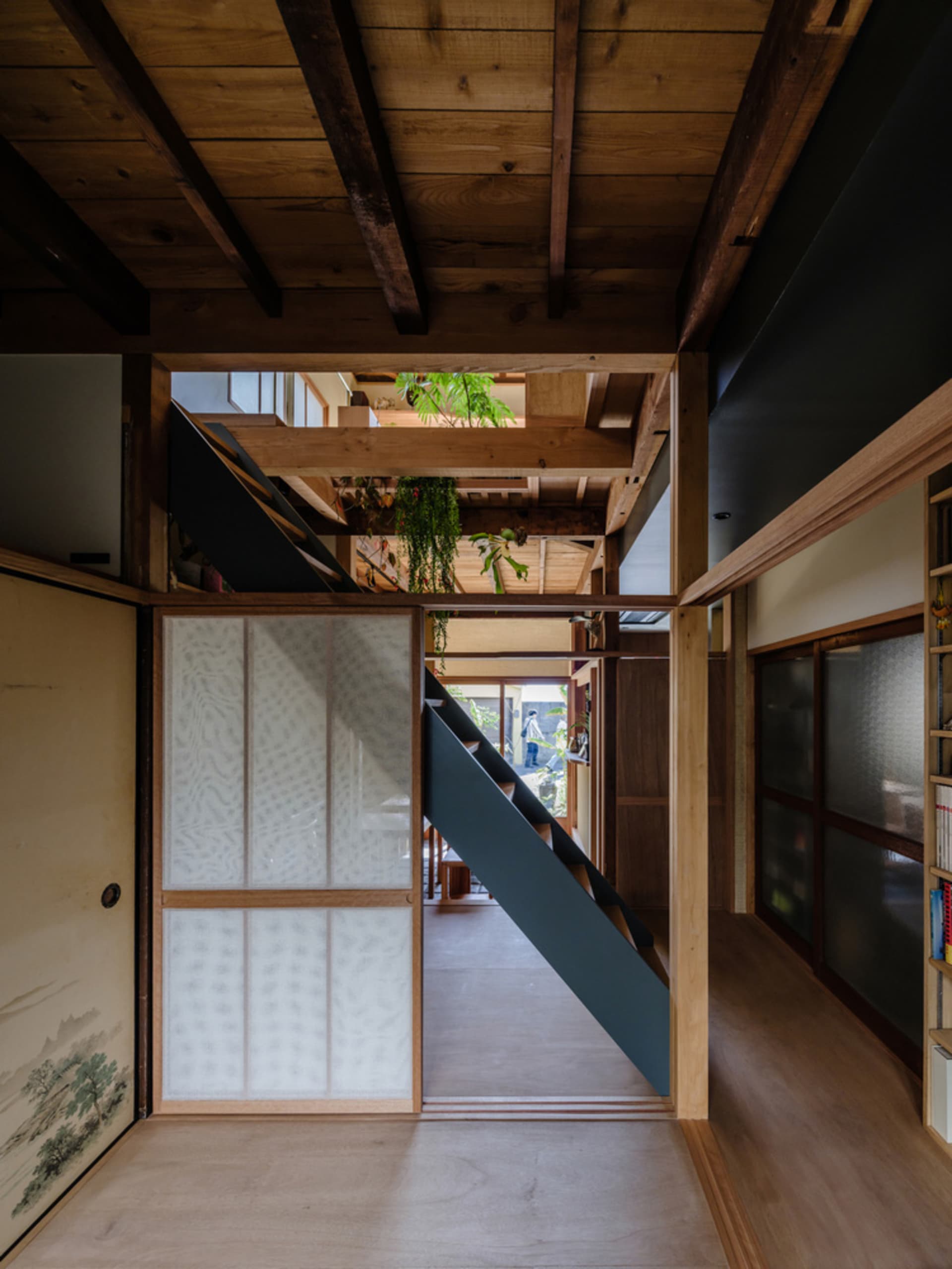 A minimalist wooden interior with a staircase and other architectural elements.