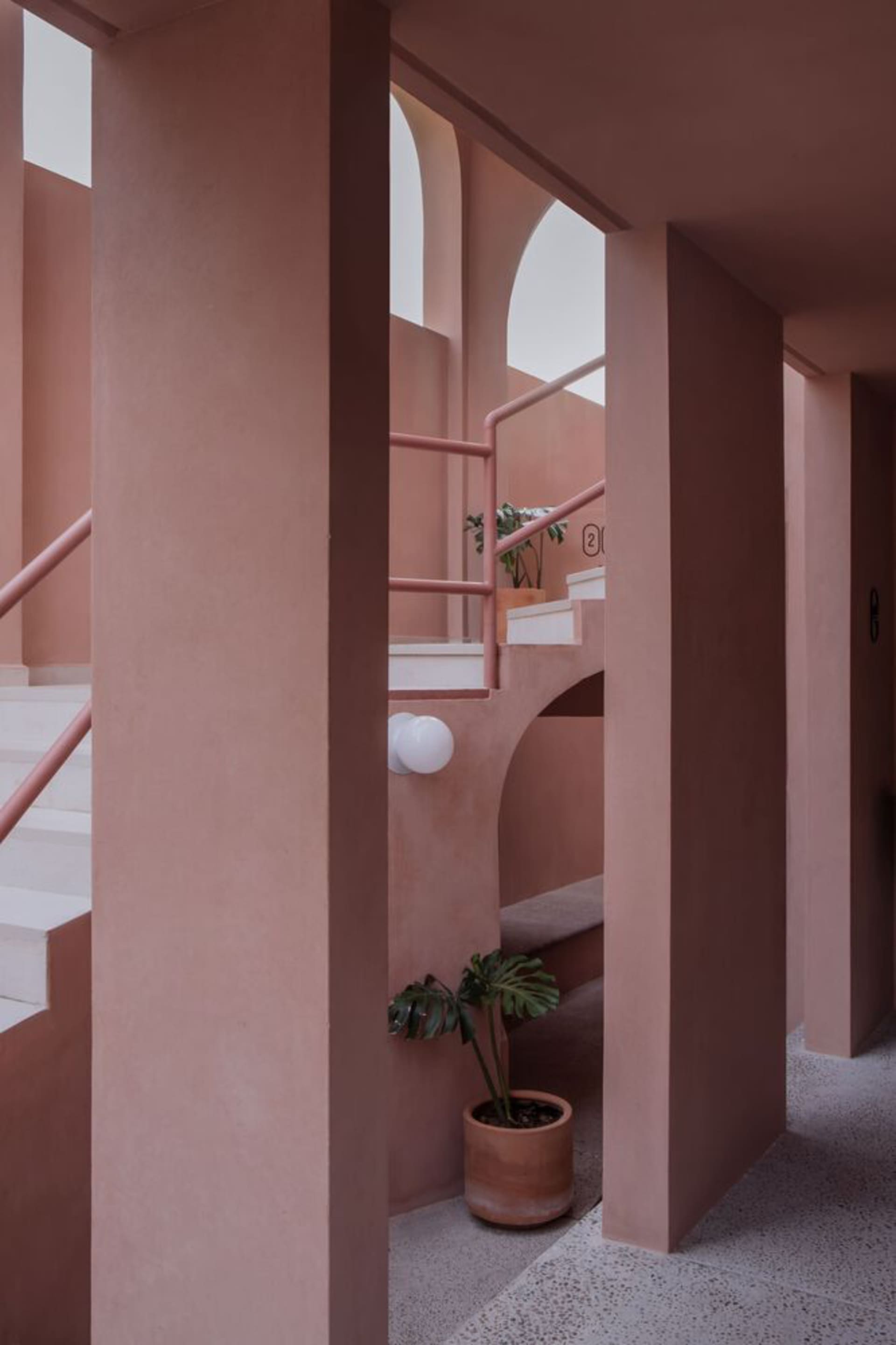 A modern residential interior with a concrete stairway and white accents.