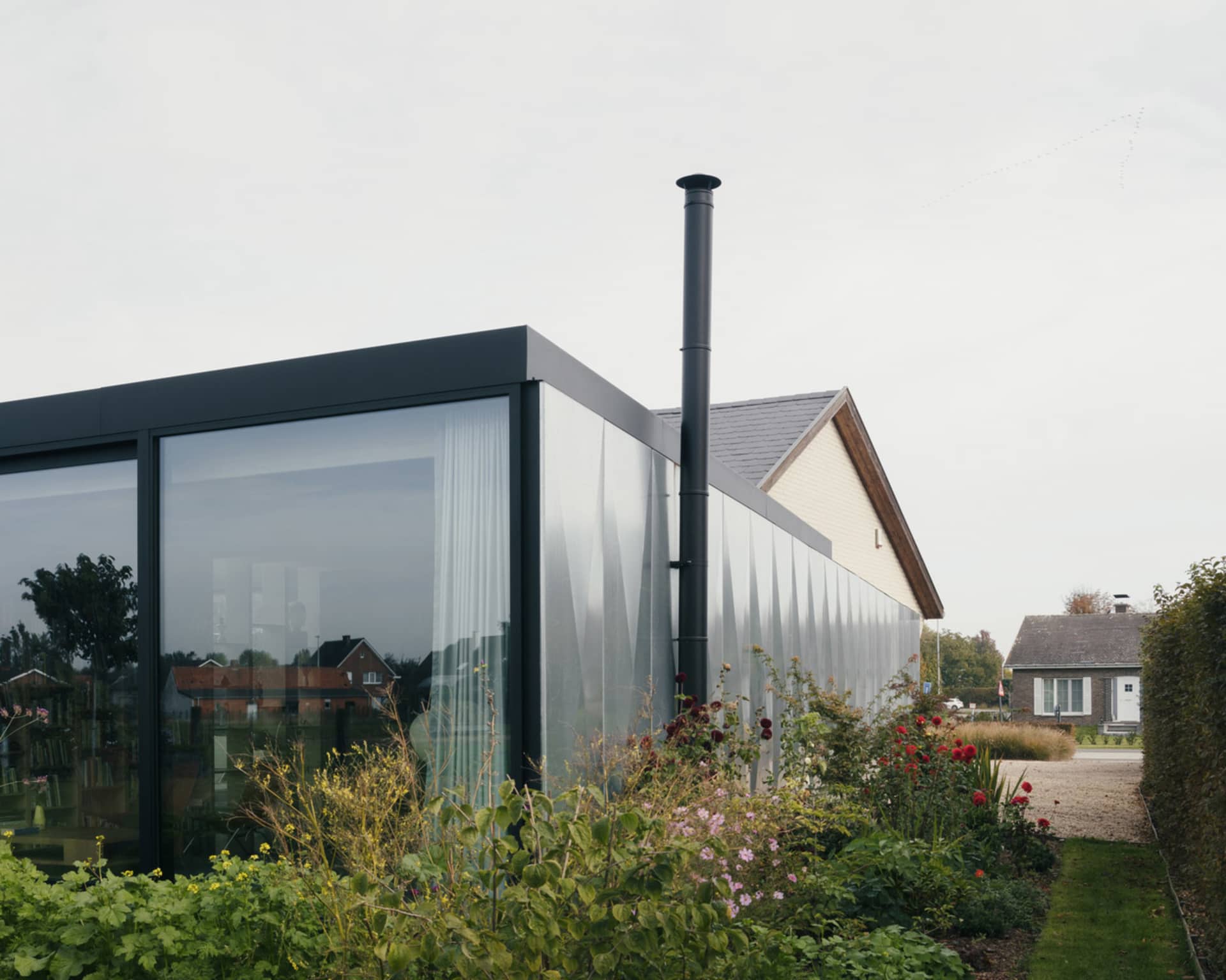 Modern house extension with large glass panels and a chimney