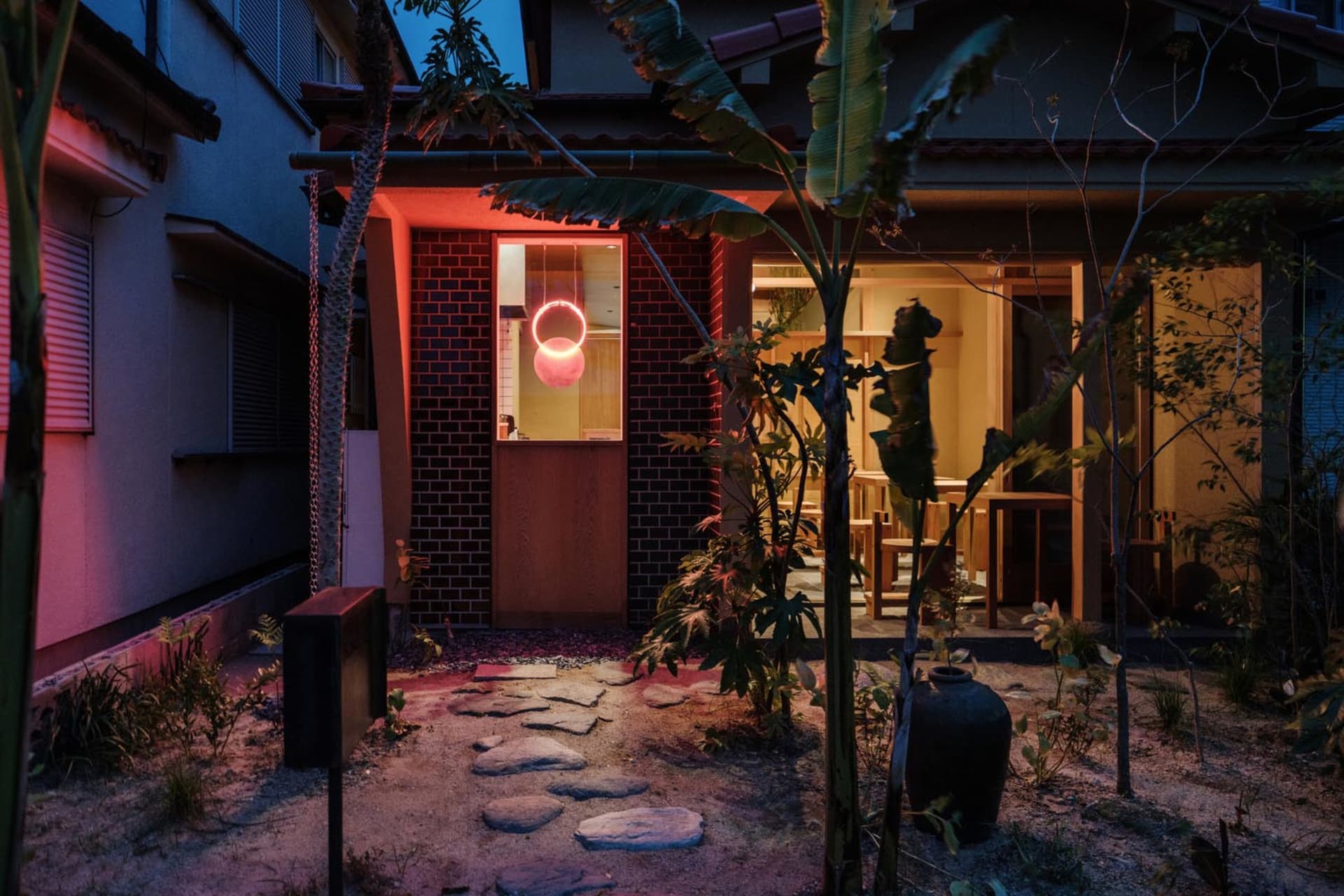夜晚餐廳外觀,紅磚牆與混凝土結構搭配燈光照明。