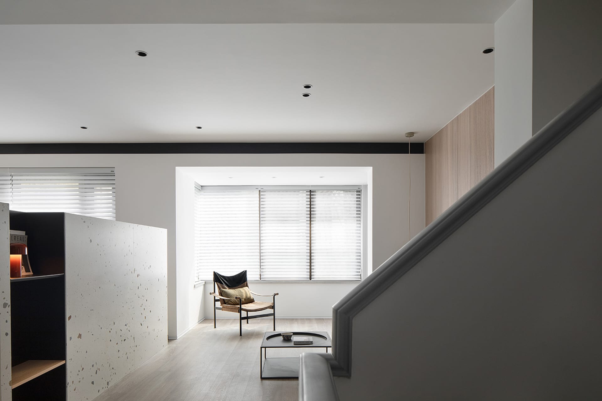Modern interior space featuring a black and white terrazzo floor and a minimalist chair.