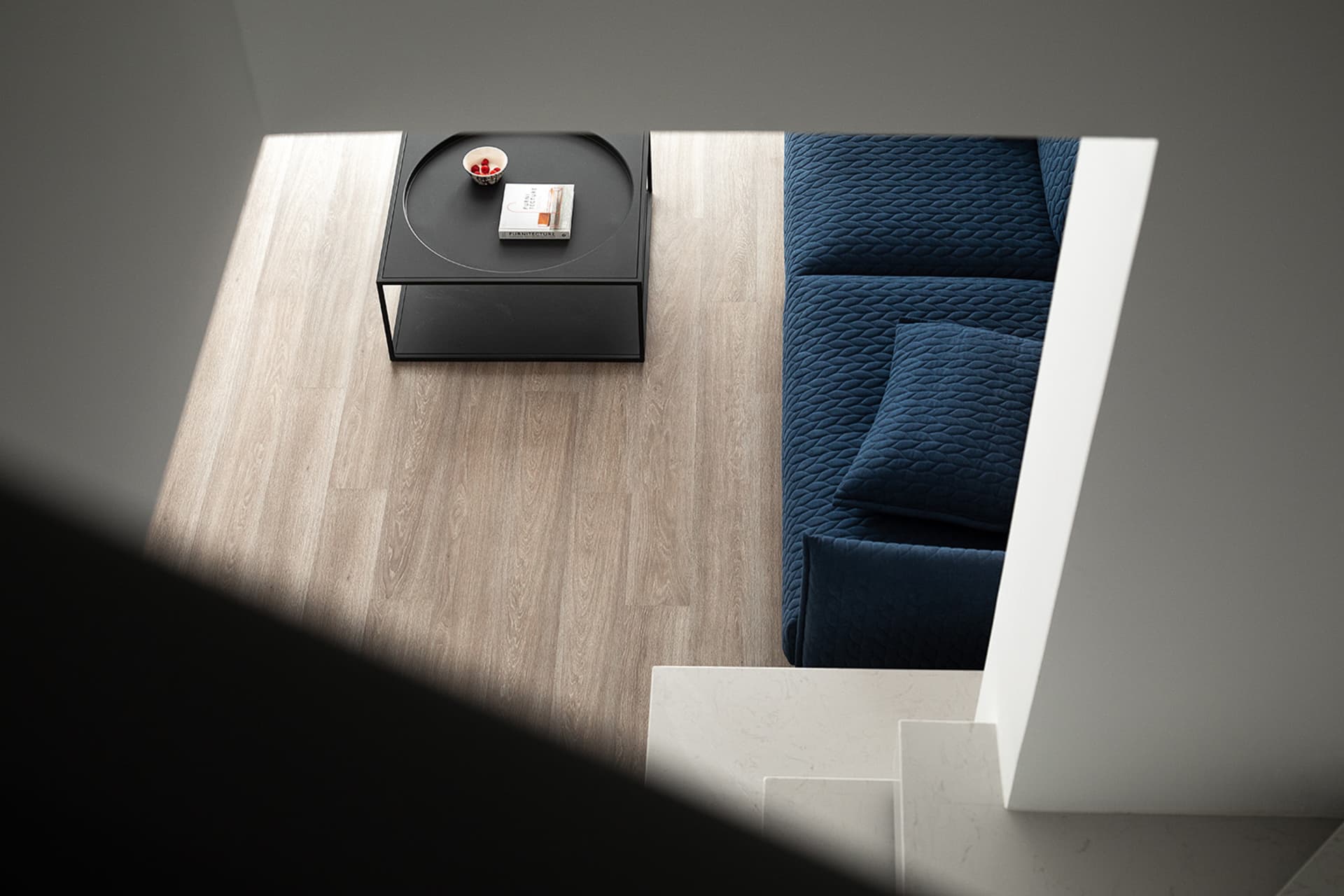 Modern living room featuring a wooden floor, fabric sofa, and metal coffee table.