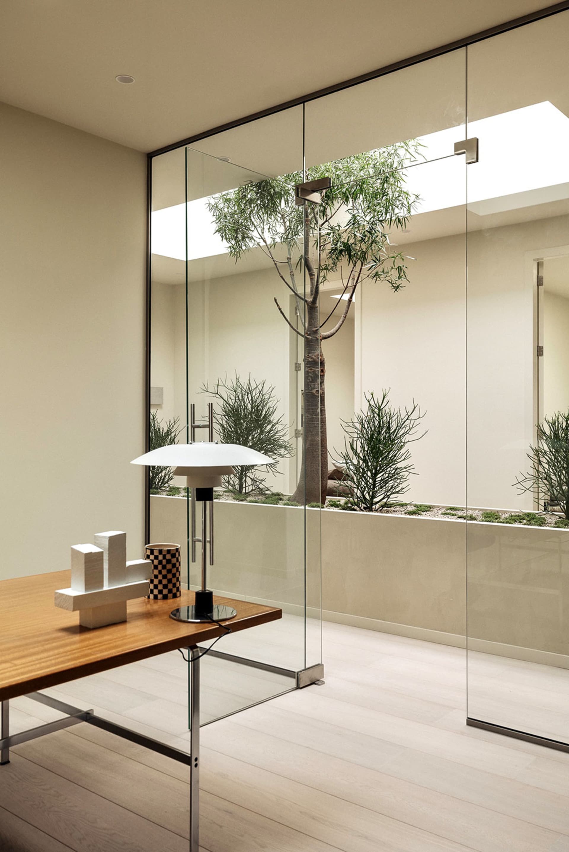 Minimalist office space featuring wooden elements and floor-to-ceiling glass wall