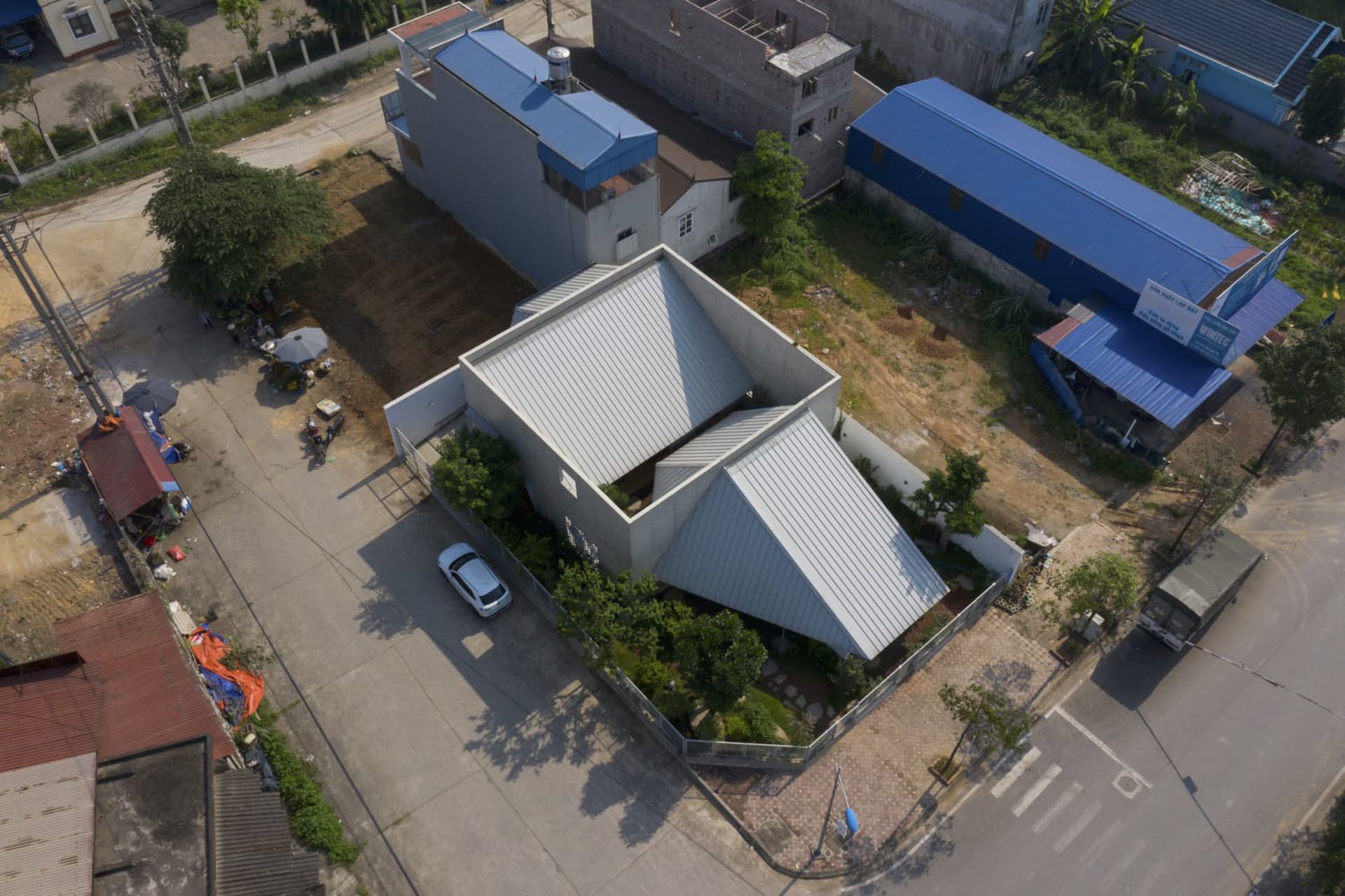 A modern house with a metal exterior, featuring a unique angular roof and minimalistic design.