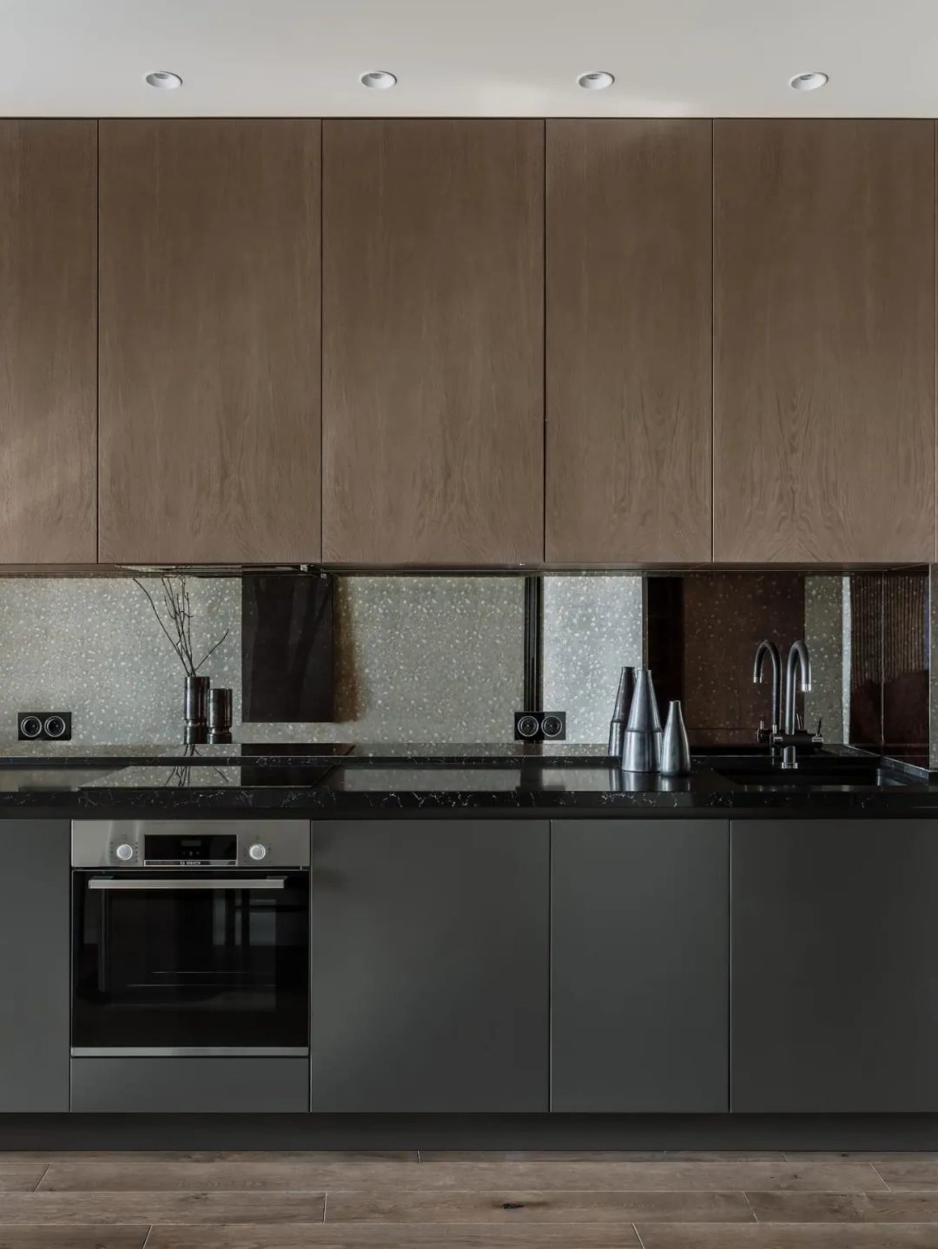 Modern kitchen with black marble countertops and stainless steel appliances.