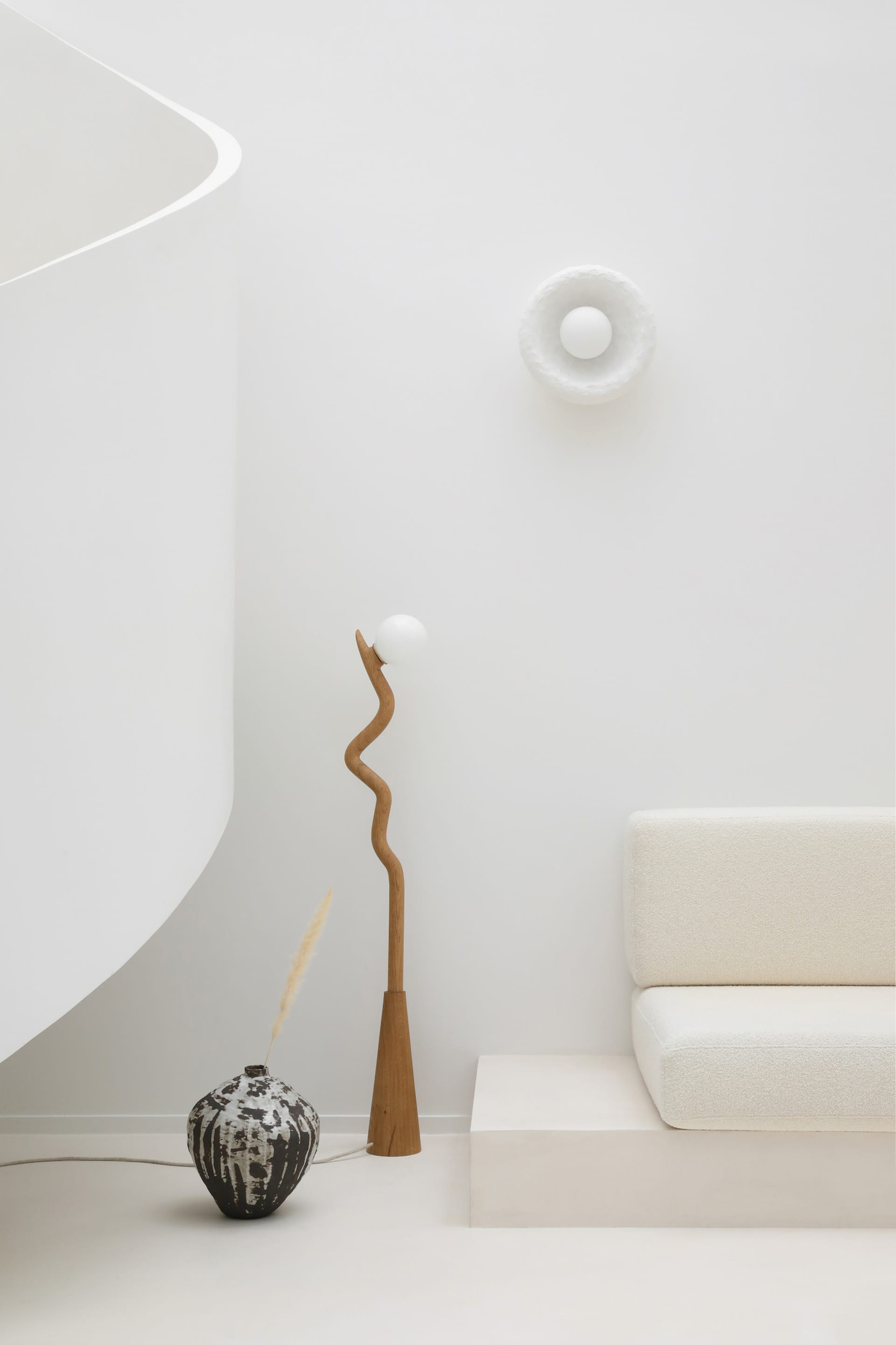 Minimalist living room featuring a modern concrete sculpture and floor lamp.