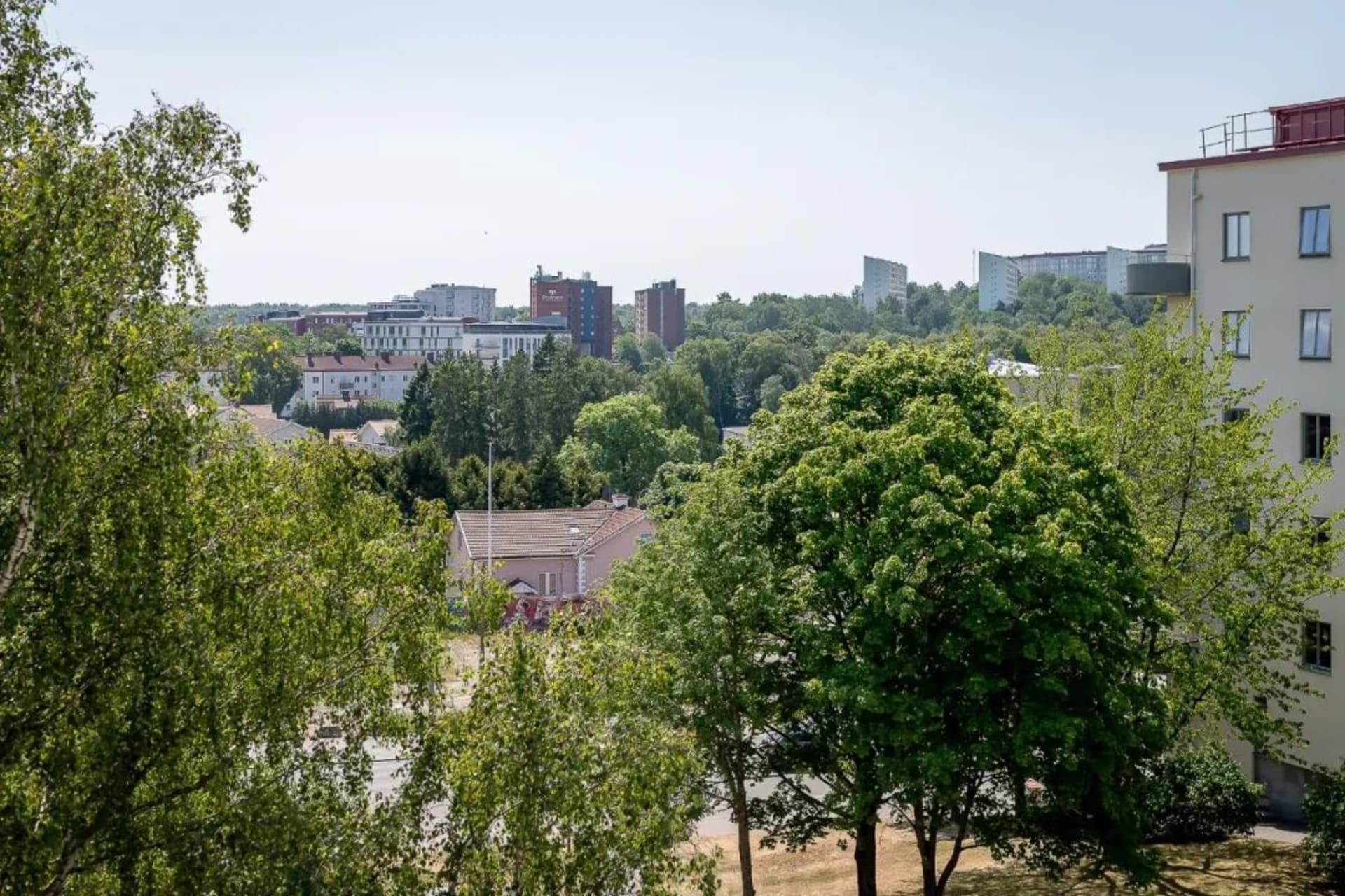 A residential development featuring concrete buildings and lush greenery.
