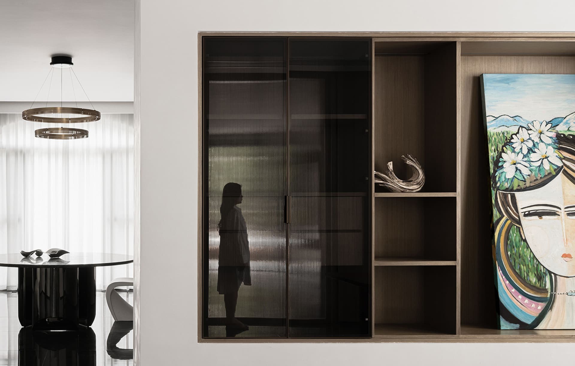 A modern living room featuring a sleek storage unit with glass doors and wooden accents.