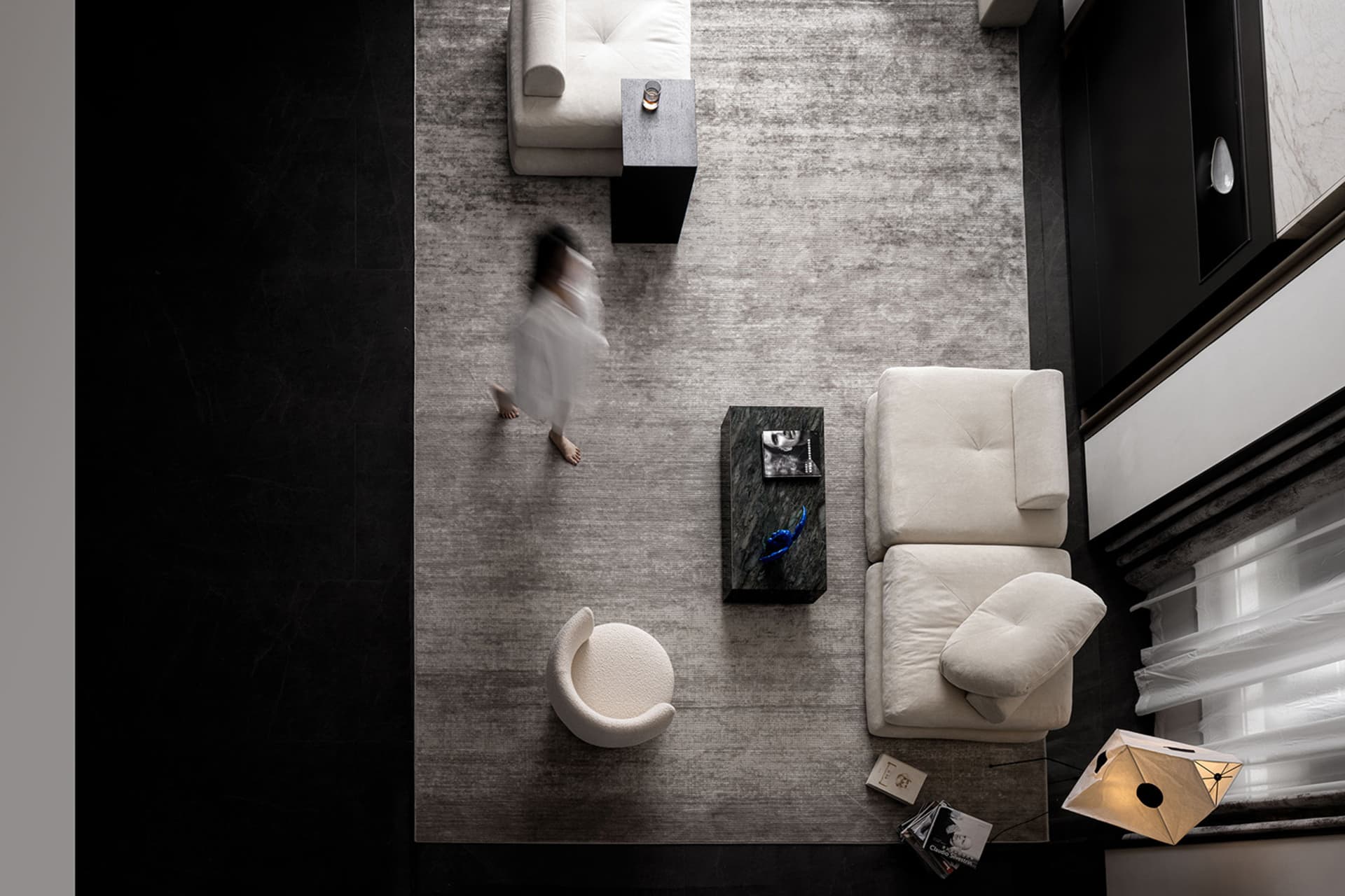 An overhead view of a modern interior design with white sofas and fabric upholstery.