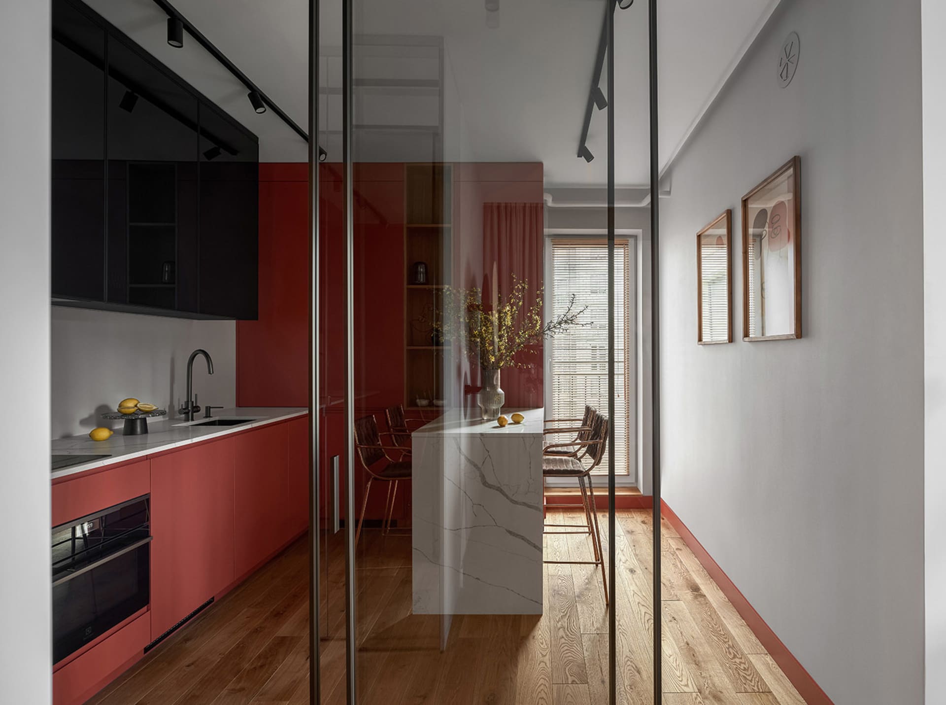Modern kitchen with red cabinets and a white marble countertop.