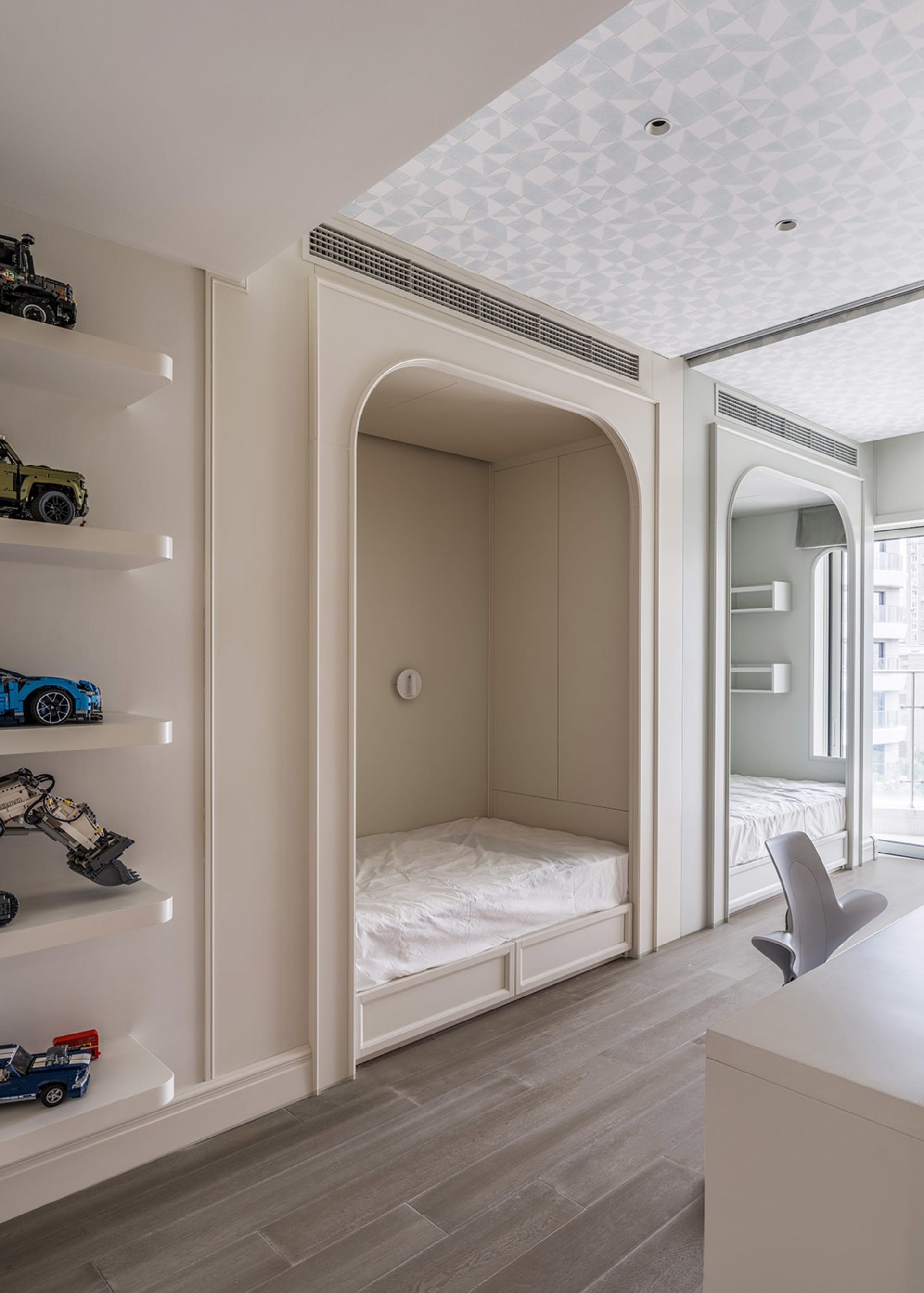 A modern minimalist bedroom with a built-in bunk bed and a desk area.