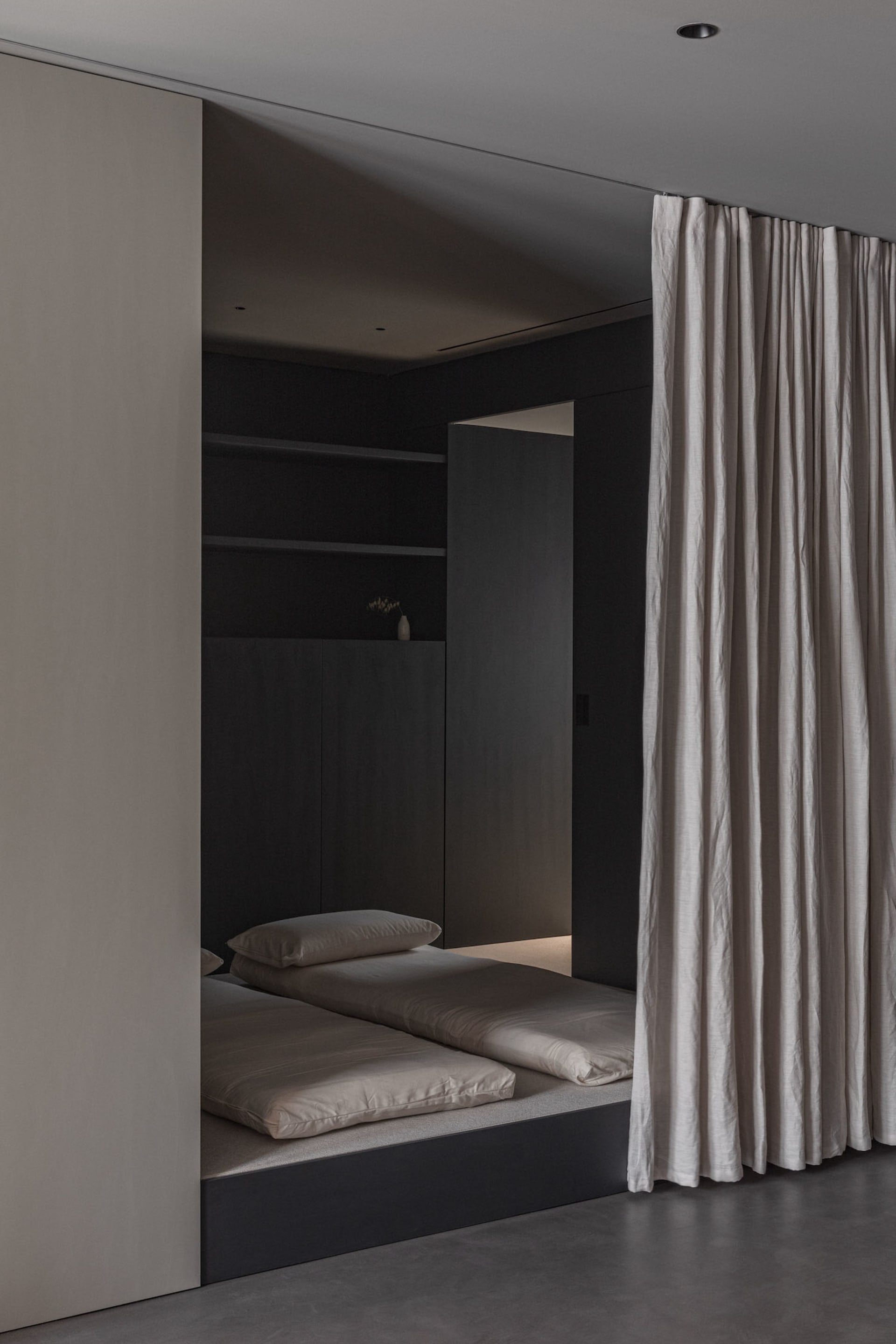 A minimalist bedroom with neutral tones and a simple, modern design.