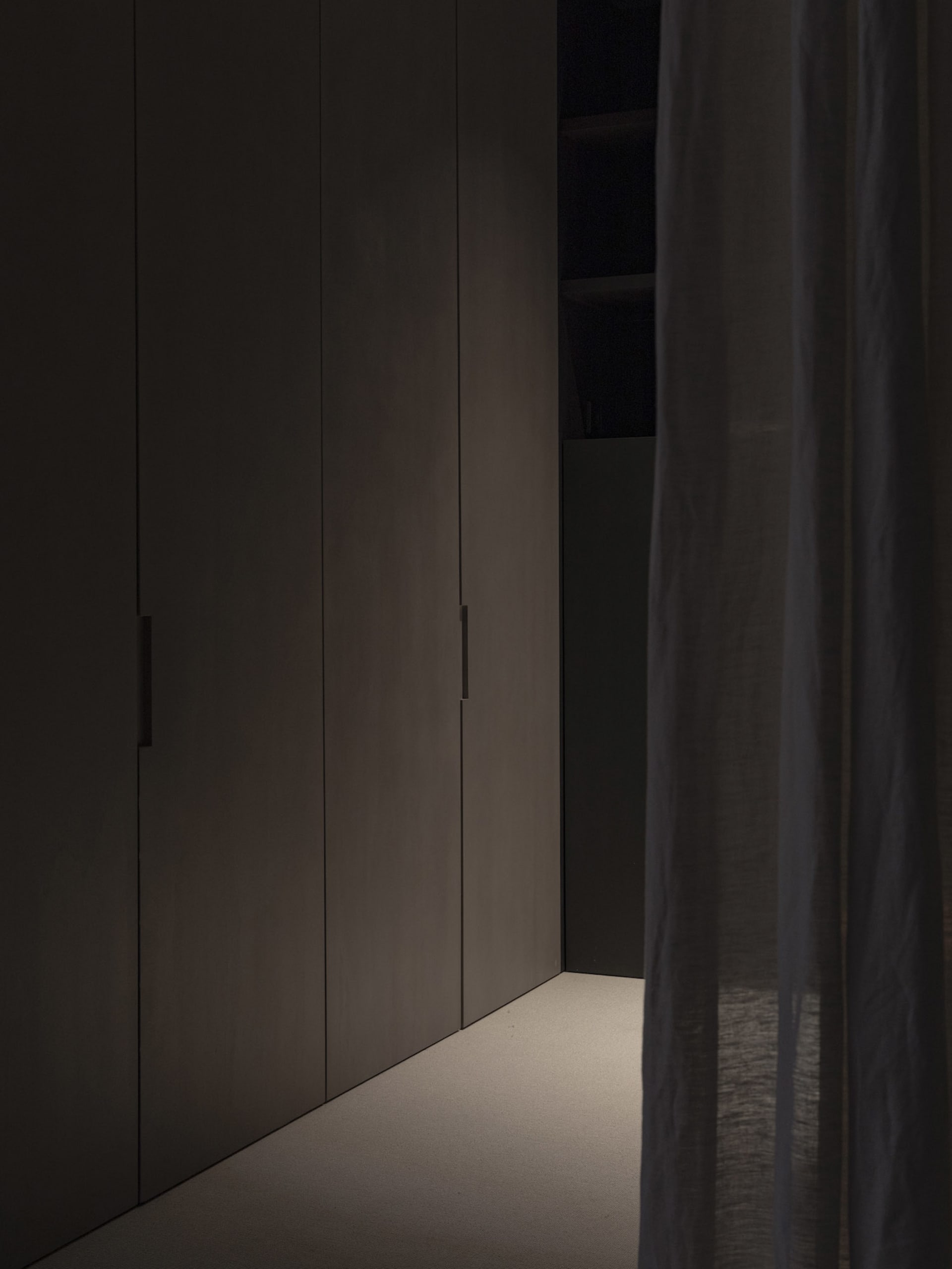 A modern minimalist interior space with dark neutral colors