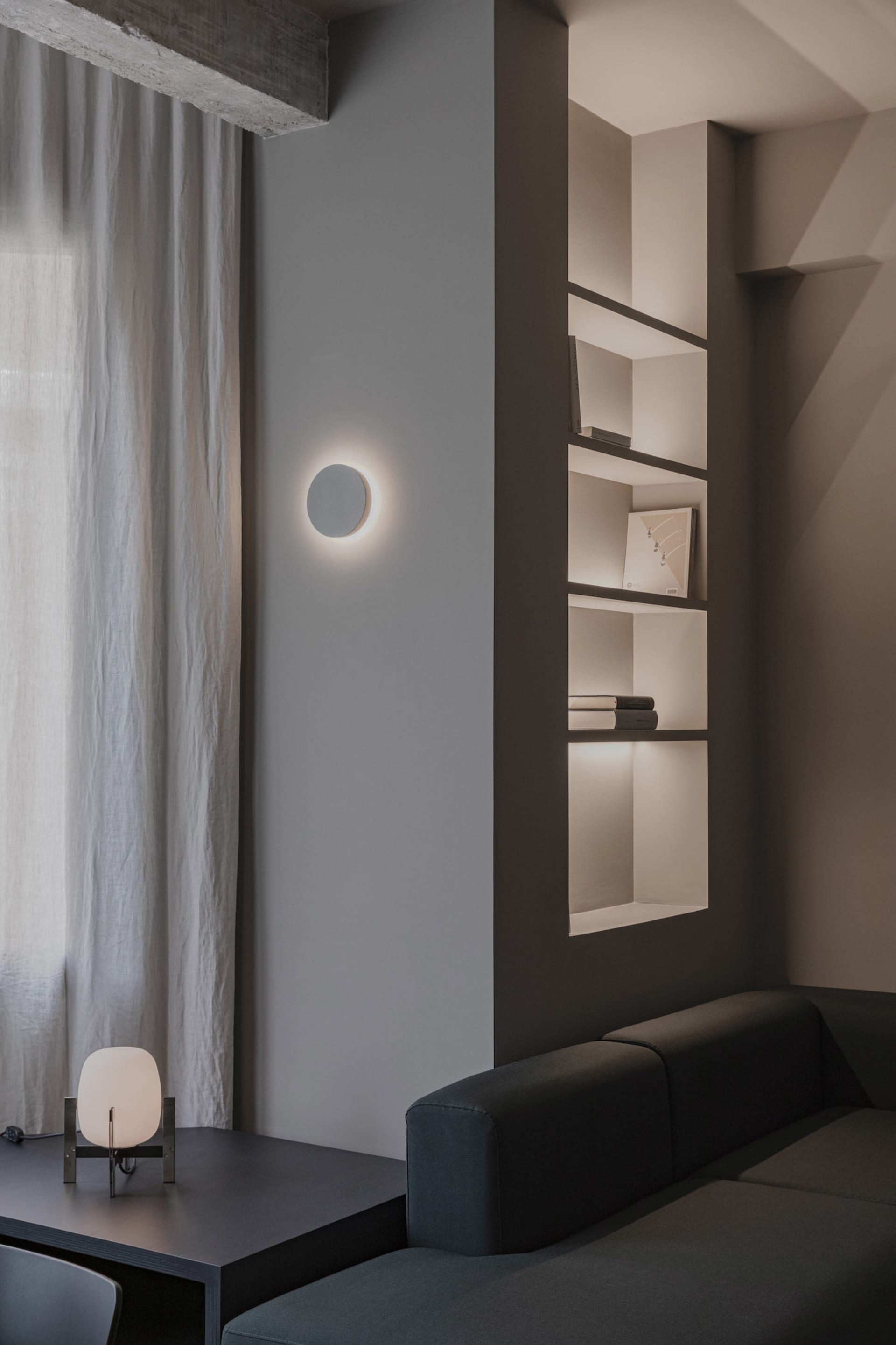 A minimalist residential space featuring concrete and white materials.