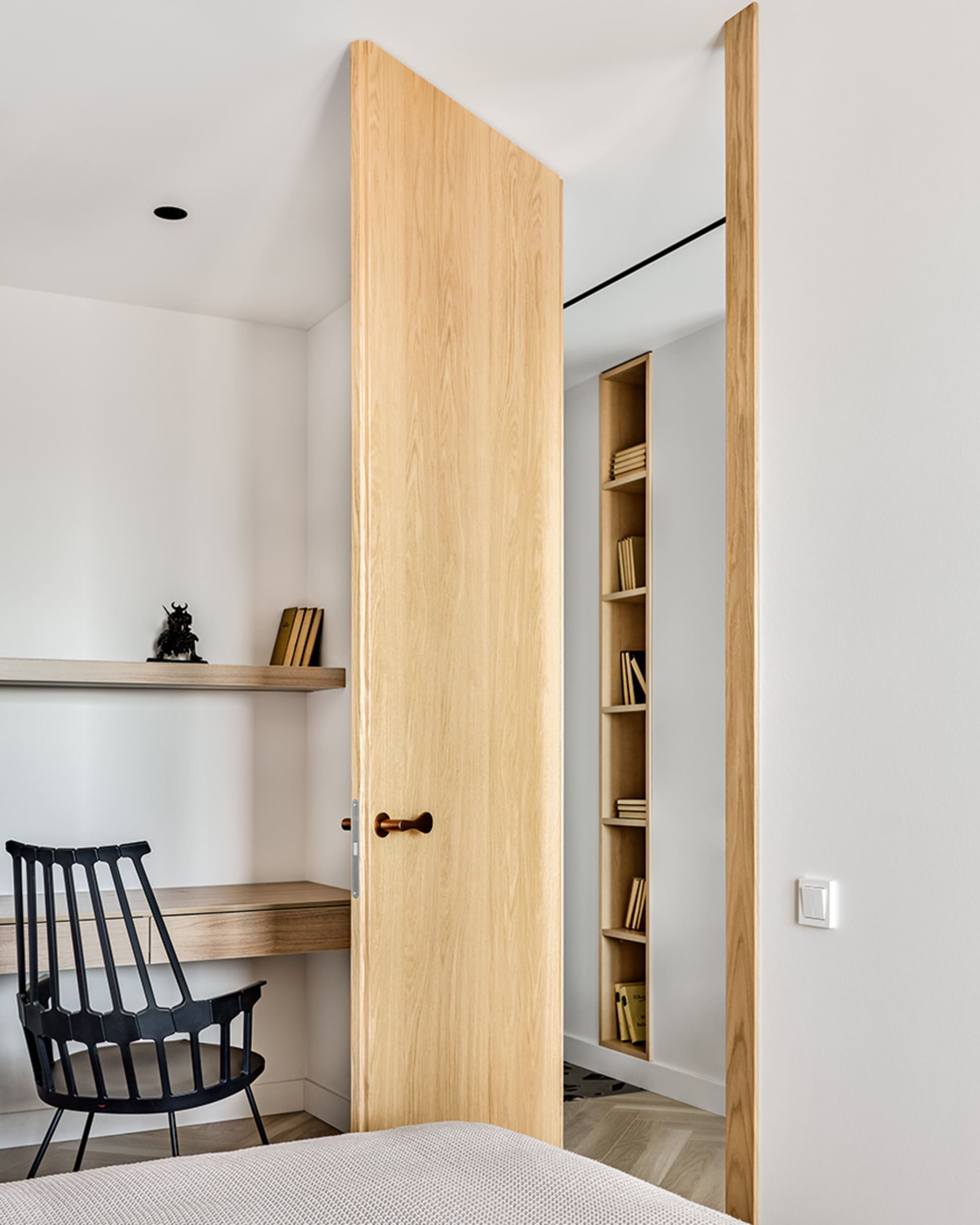 Modern minimalist bedroom with wooden furniture and open shelving.