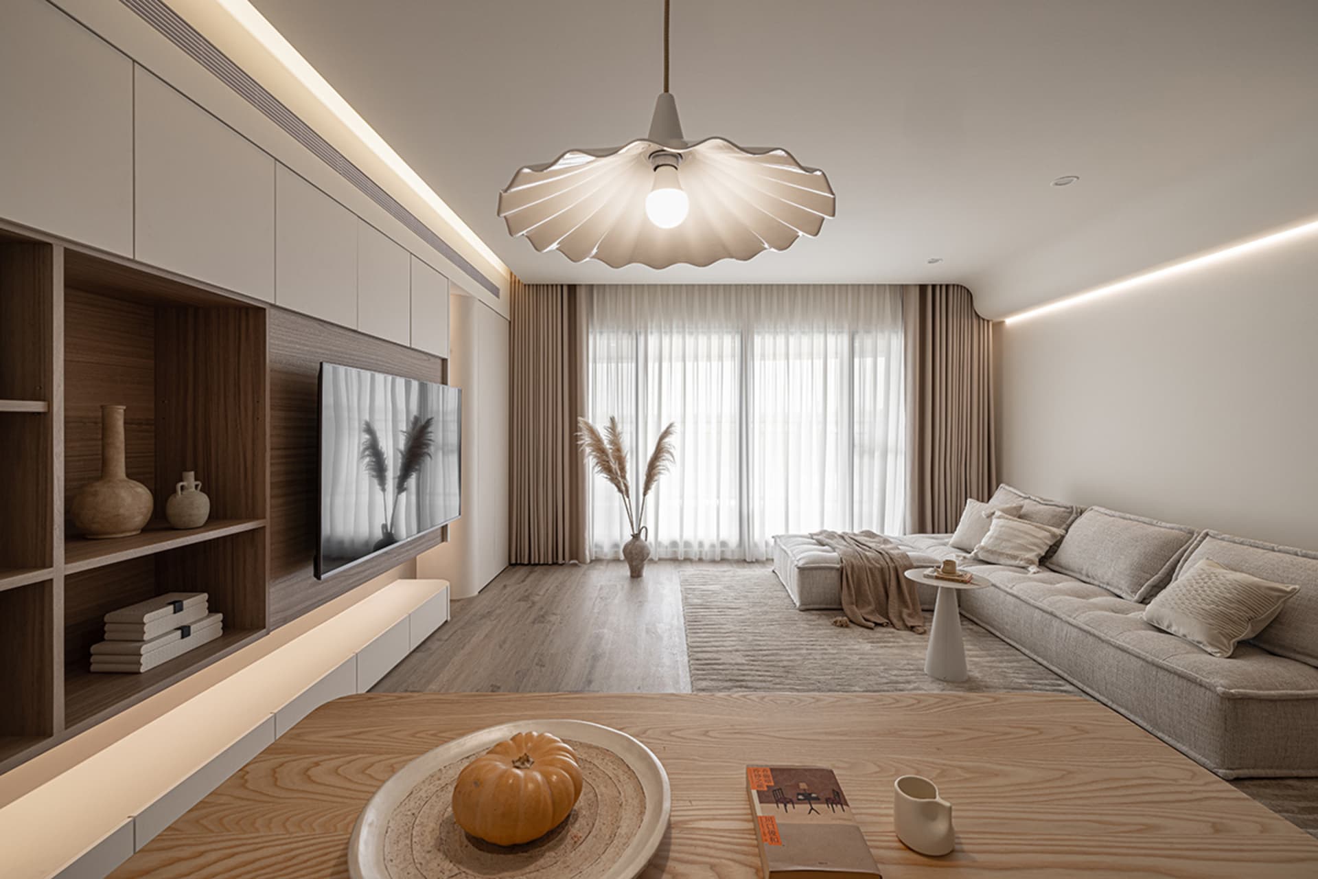 A modern minimalist living room with a sofa, coffee table, and decorative elements.