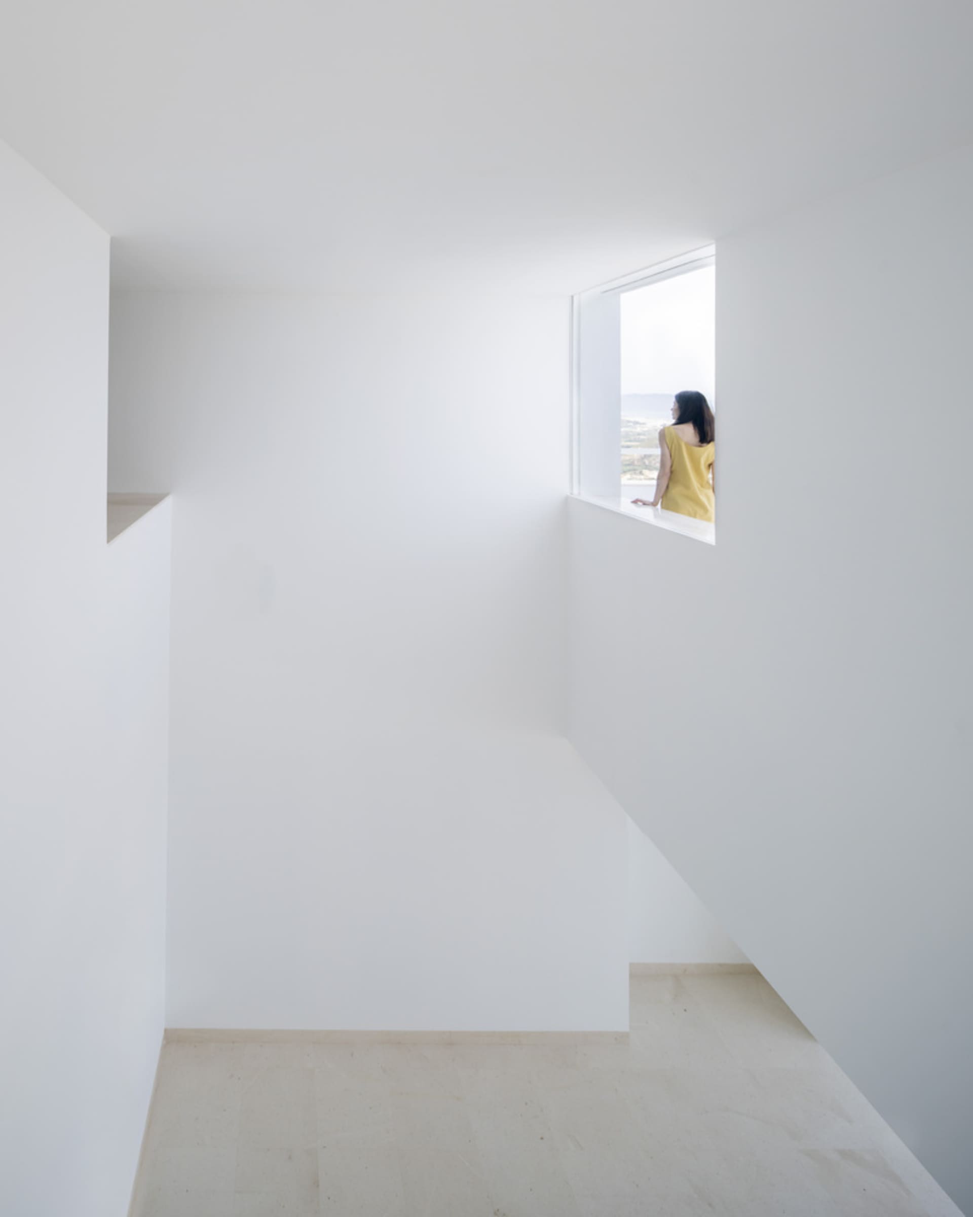 極簡白色房間，窗邊展示雕塑作品。