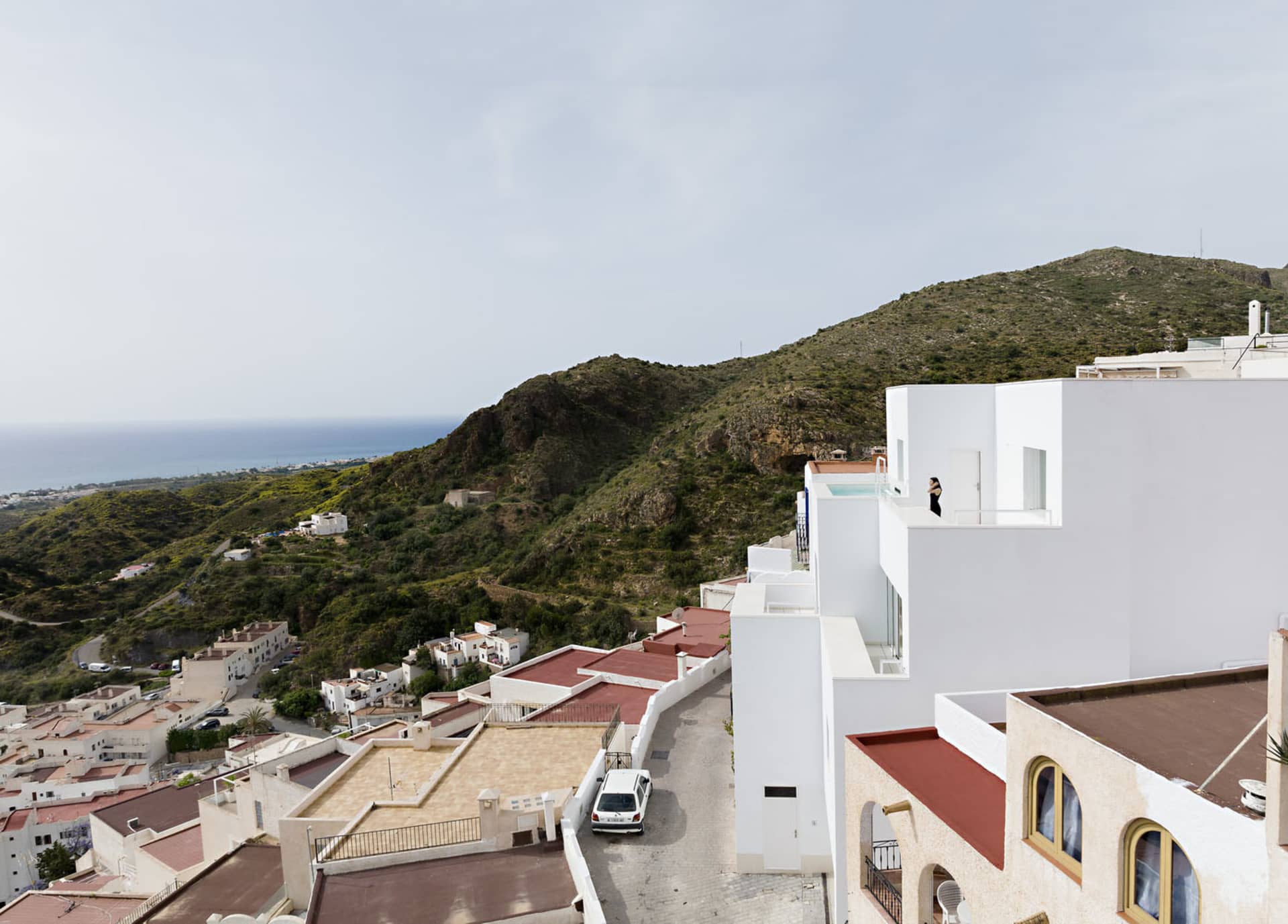 Modern architectural design featuring concrete buildings and a scenic mountain backdrop.